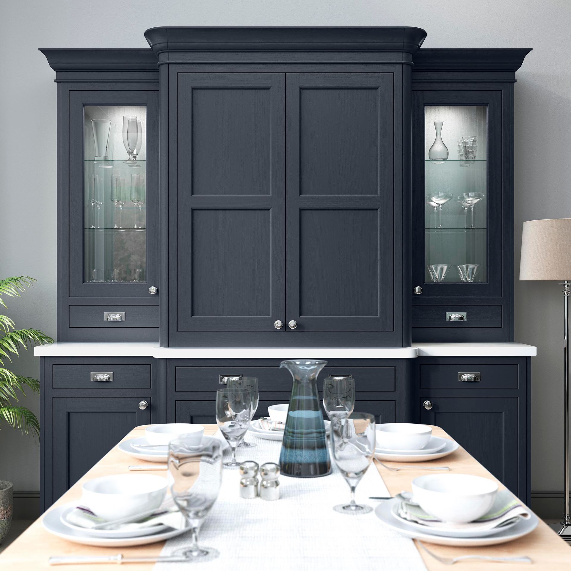 A dark blue hutch with glass-front cabinets above a dining table set for a meal.