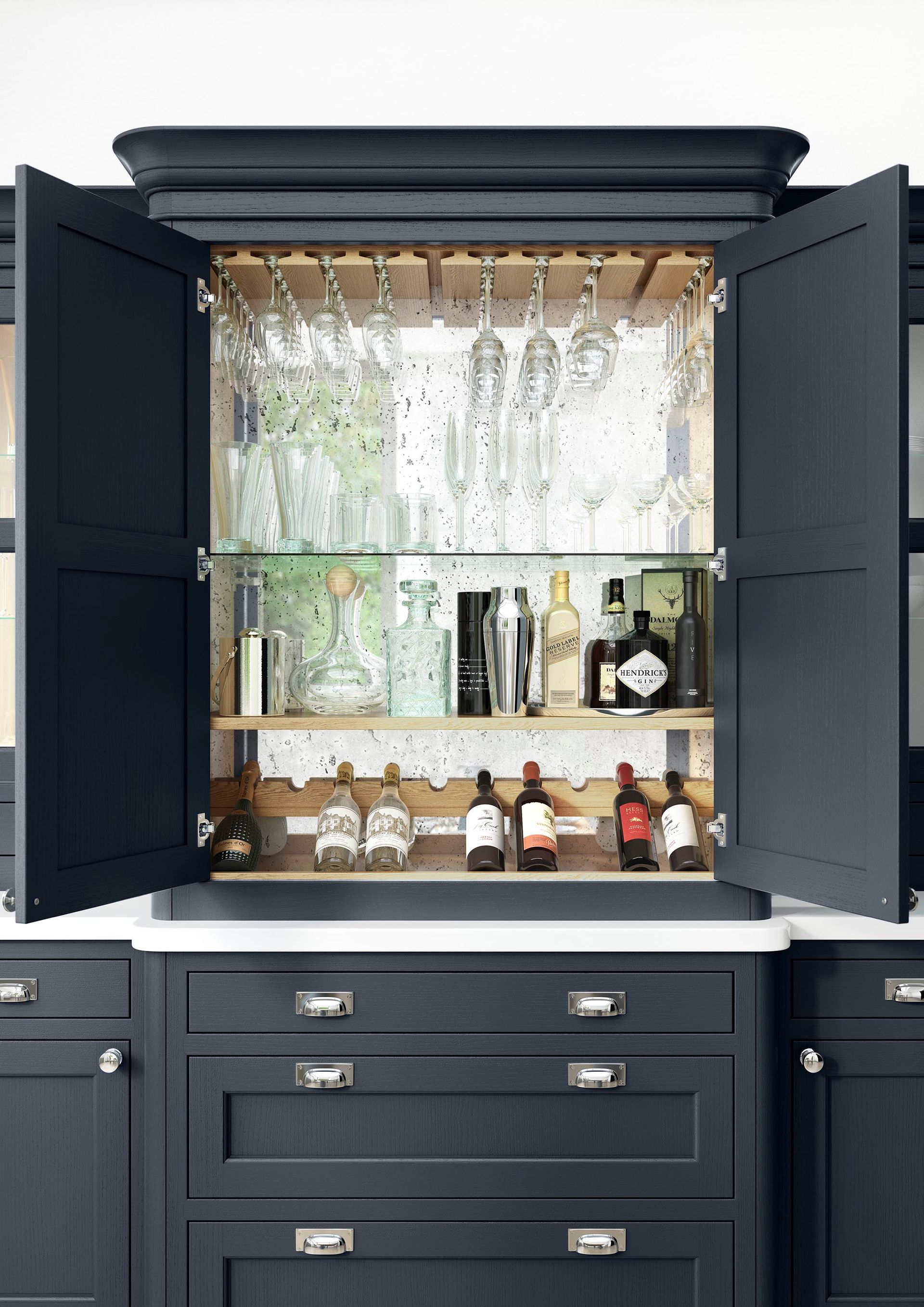 A dark blue kitchen cabinet with open doors revealing a mirrored cocktail bar stocked with bottles and hanging glassware.