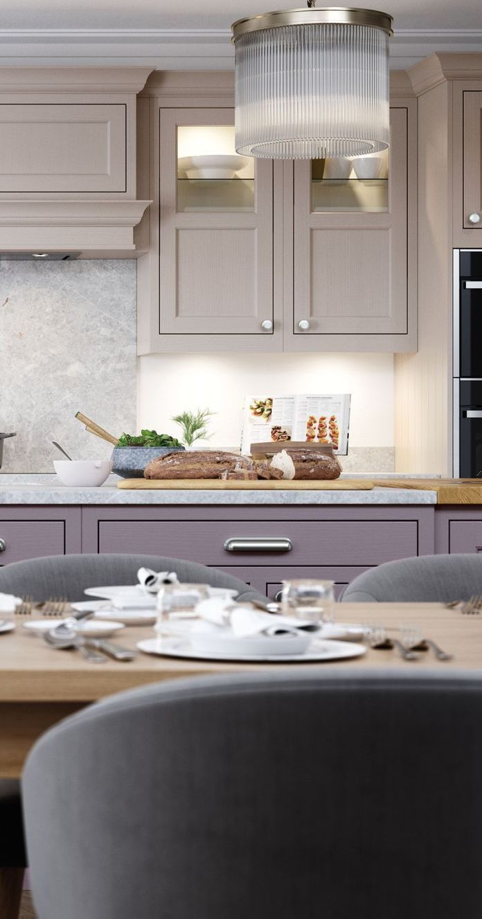 A modern dining room table in the foreground with a view of a sleek, taupe-colored kitchen in the background.