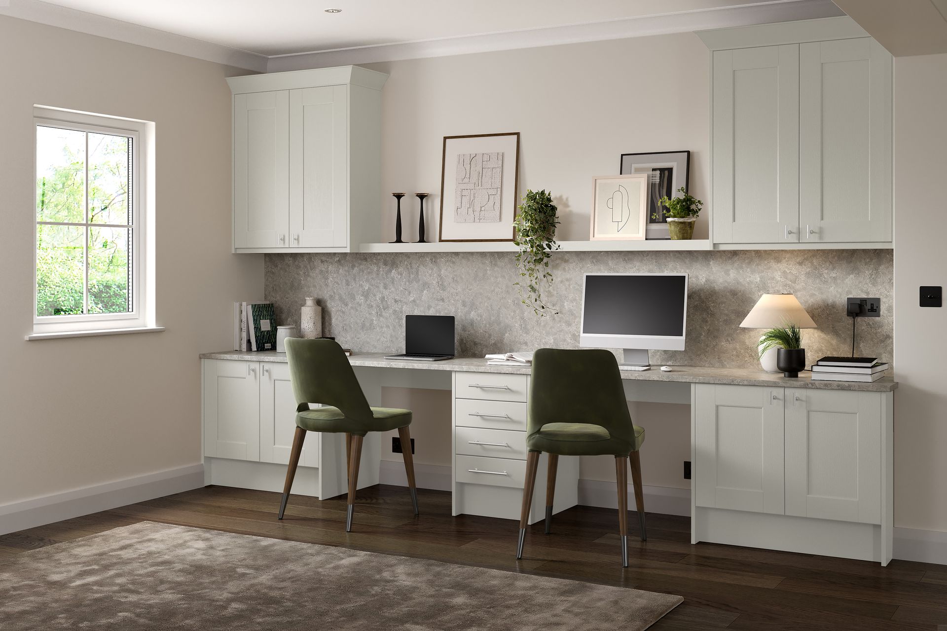 A modern home office with built-in white cabinets, a long countertop, two green chairs, and a desk lamp on a patterned wall.