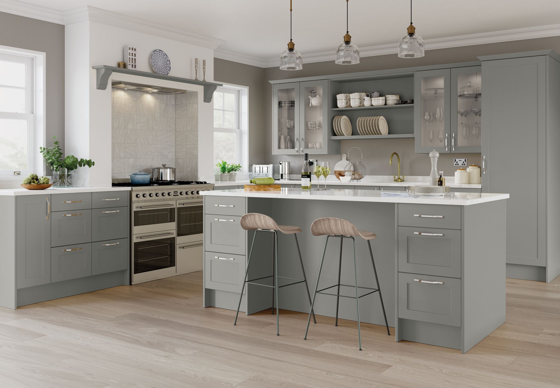 A modern kitchen featuring grey cabinets, a white island with two stools, a range cooker, and light wood flooring.