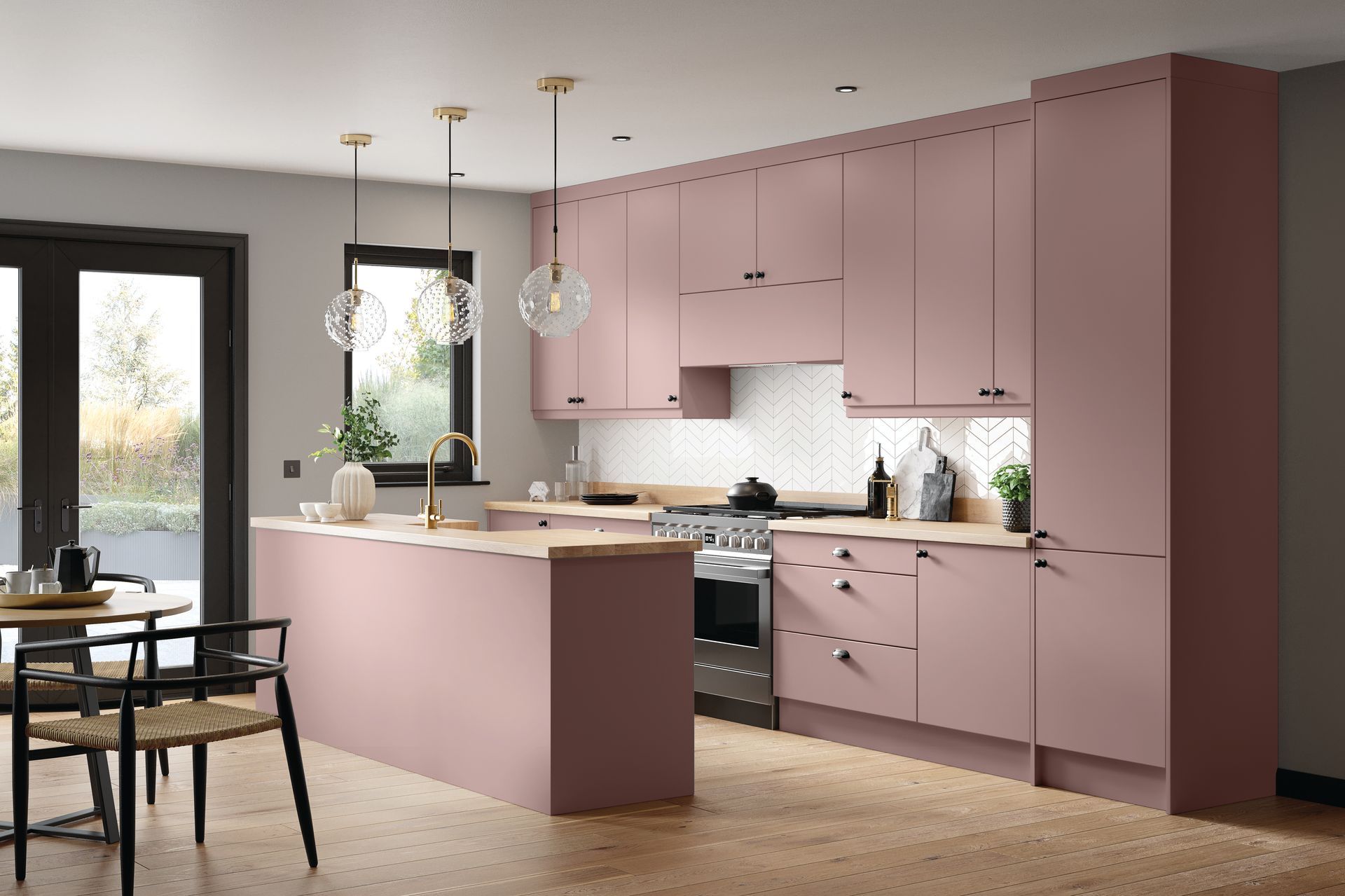 Modern kitchen with soft pink cabinetry, light wood countertops, white patterned backsplash, and hanging pendant lights.