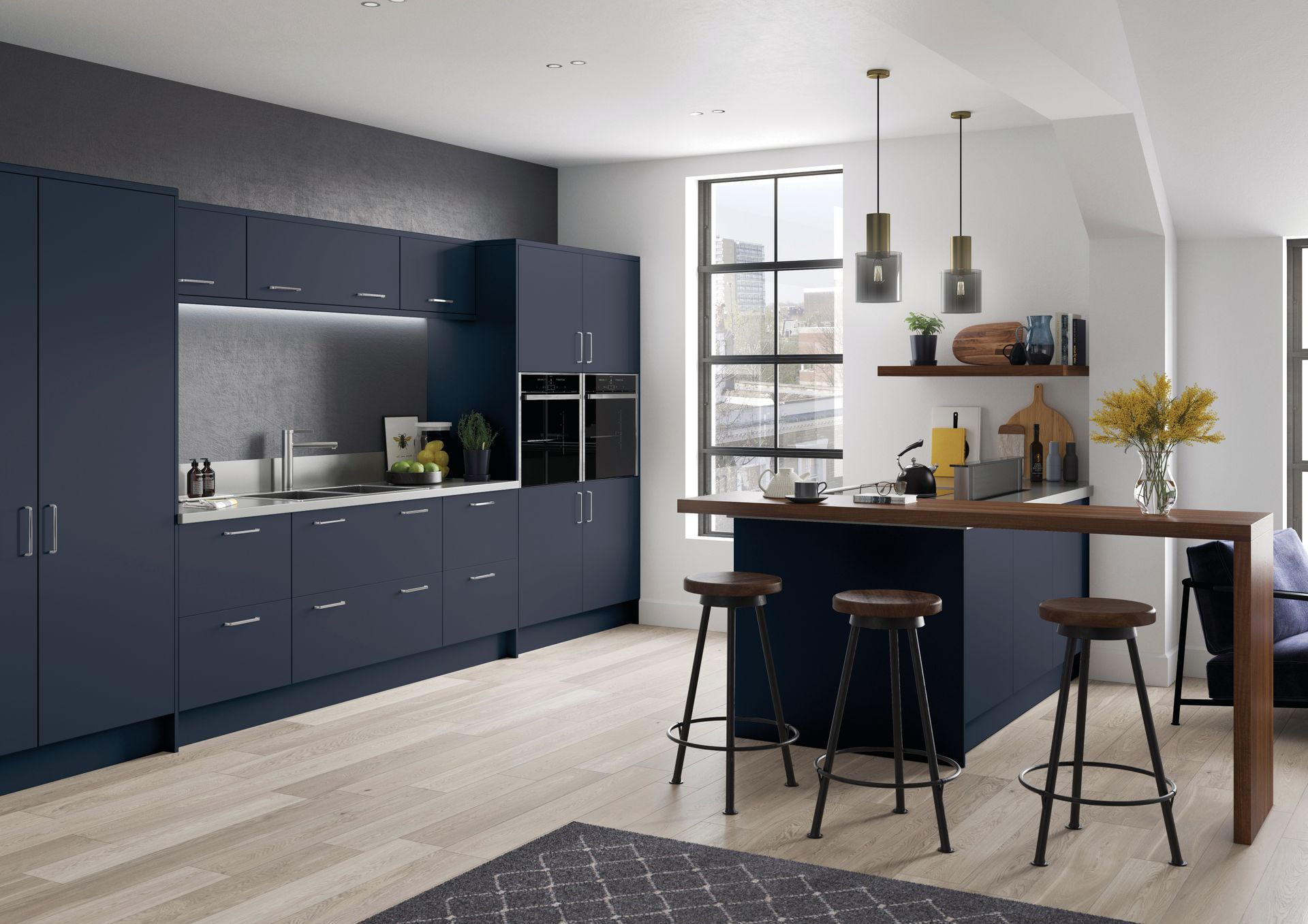 Modern kitchen with matte dark blue cabinets, light wood flooring, and a wooden breakfast bar with three stools.