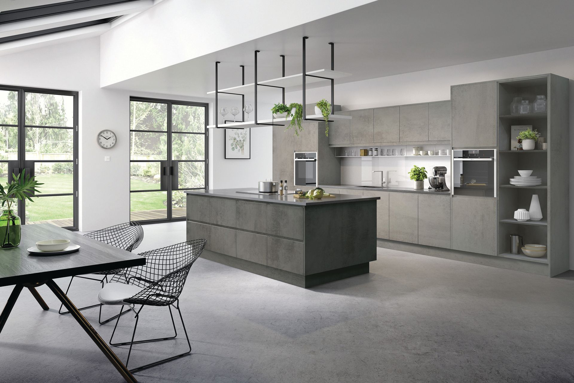 Modern kitchen with a dark grey central island, light wood cabinets, hanging shelving, and an adjacent dining area.