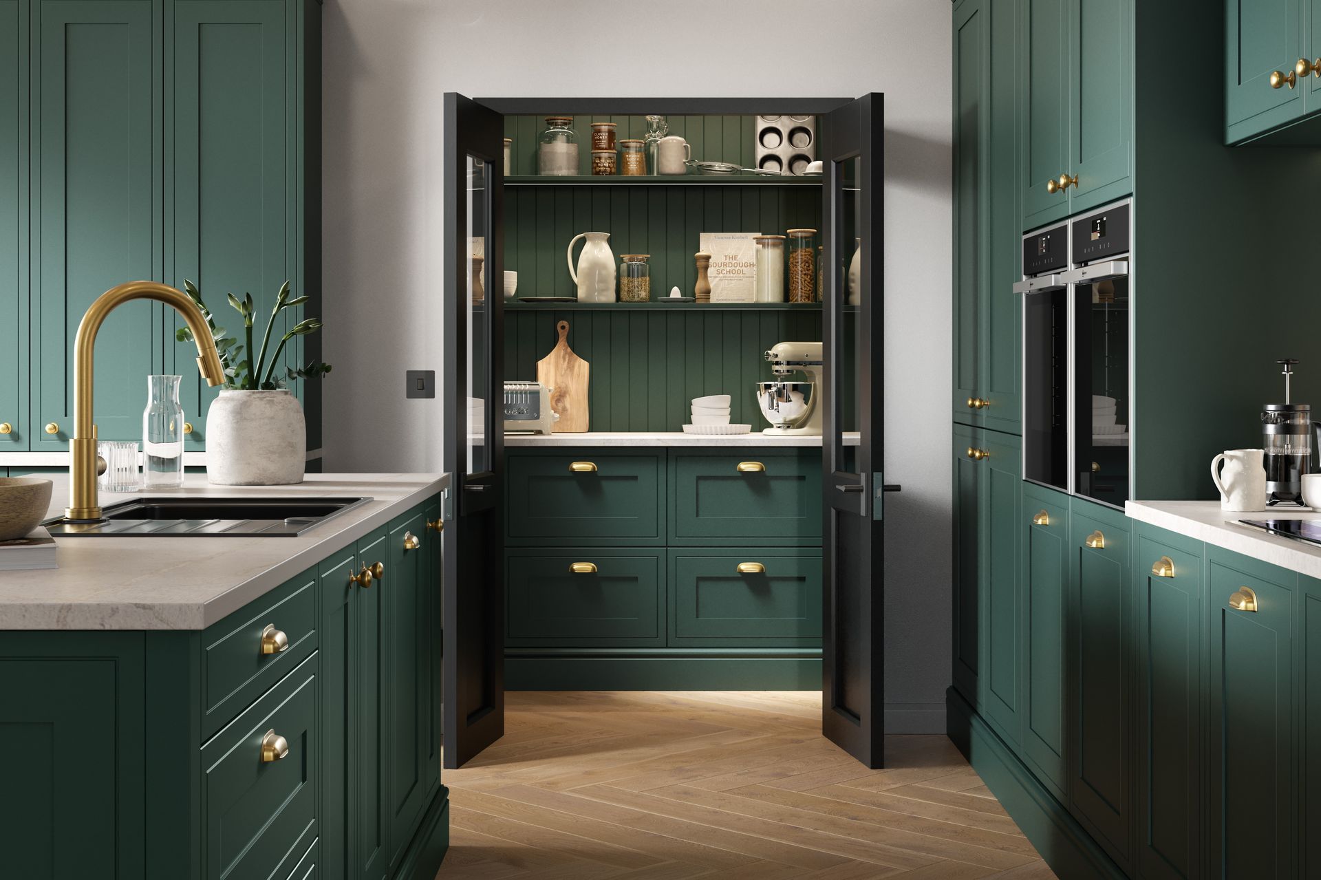 A dark green kitchen with a central island, brass fixtures, and an open pantry with shelves and base drawers.