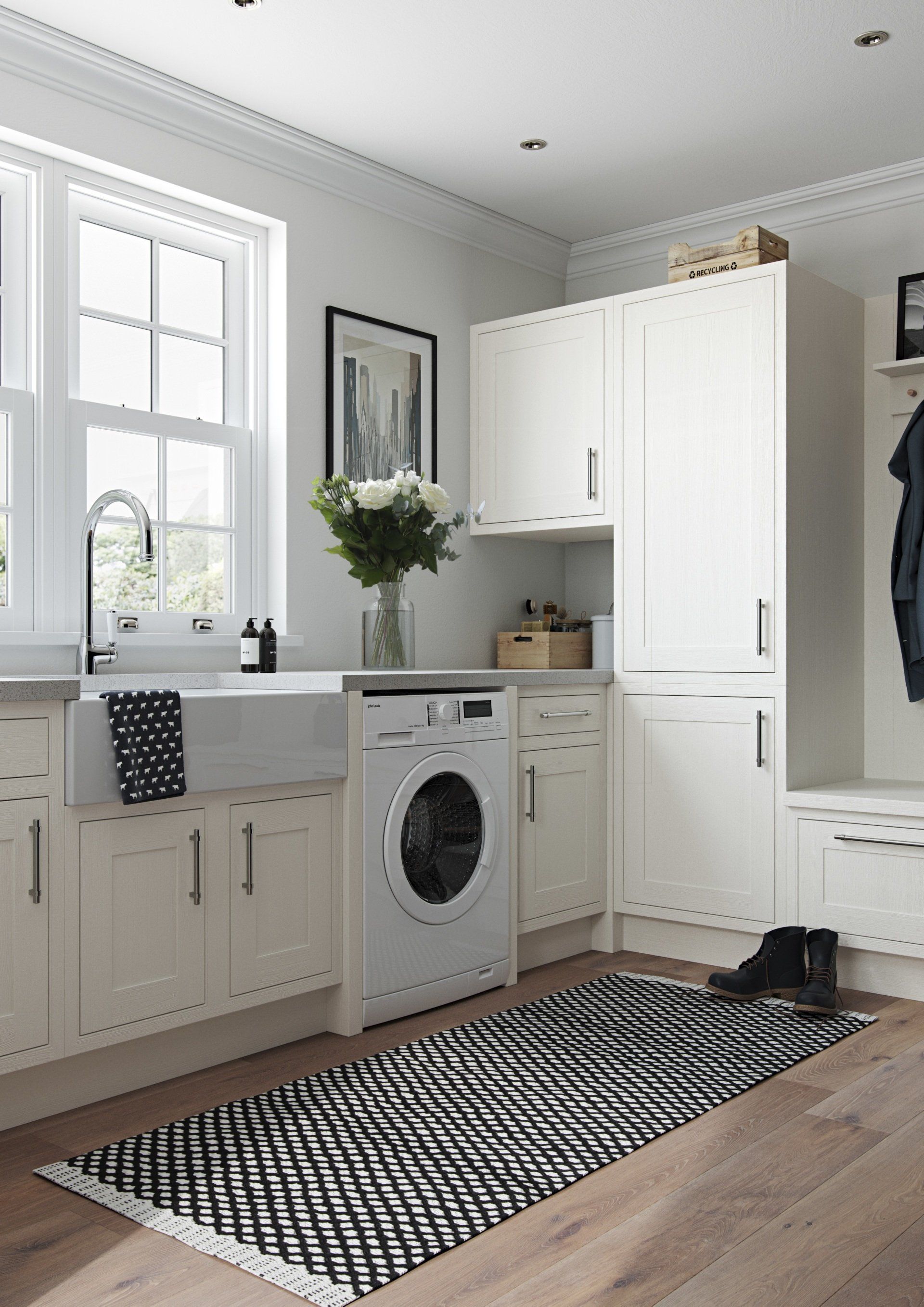 A bright, modern laundry room with white cabinets, a farmhouse sink, a washing machine, and a black-and-white patterned rug.