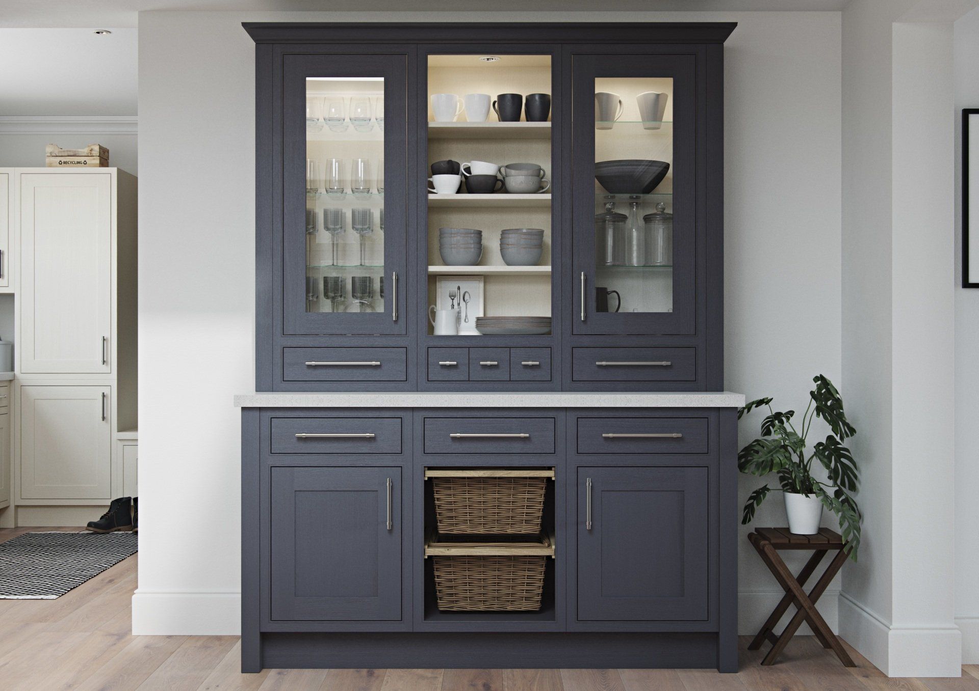 A dark gray kitchen hutch with glass cabinets, drawers, and open shelving with wicker baskets, set against a white wall.