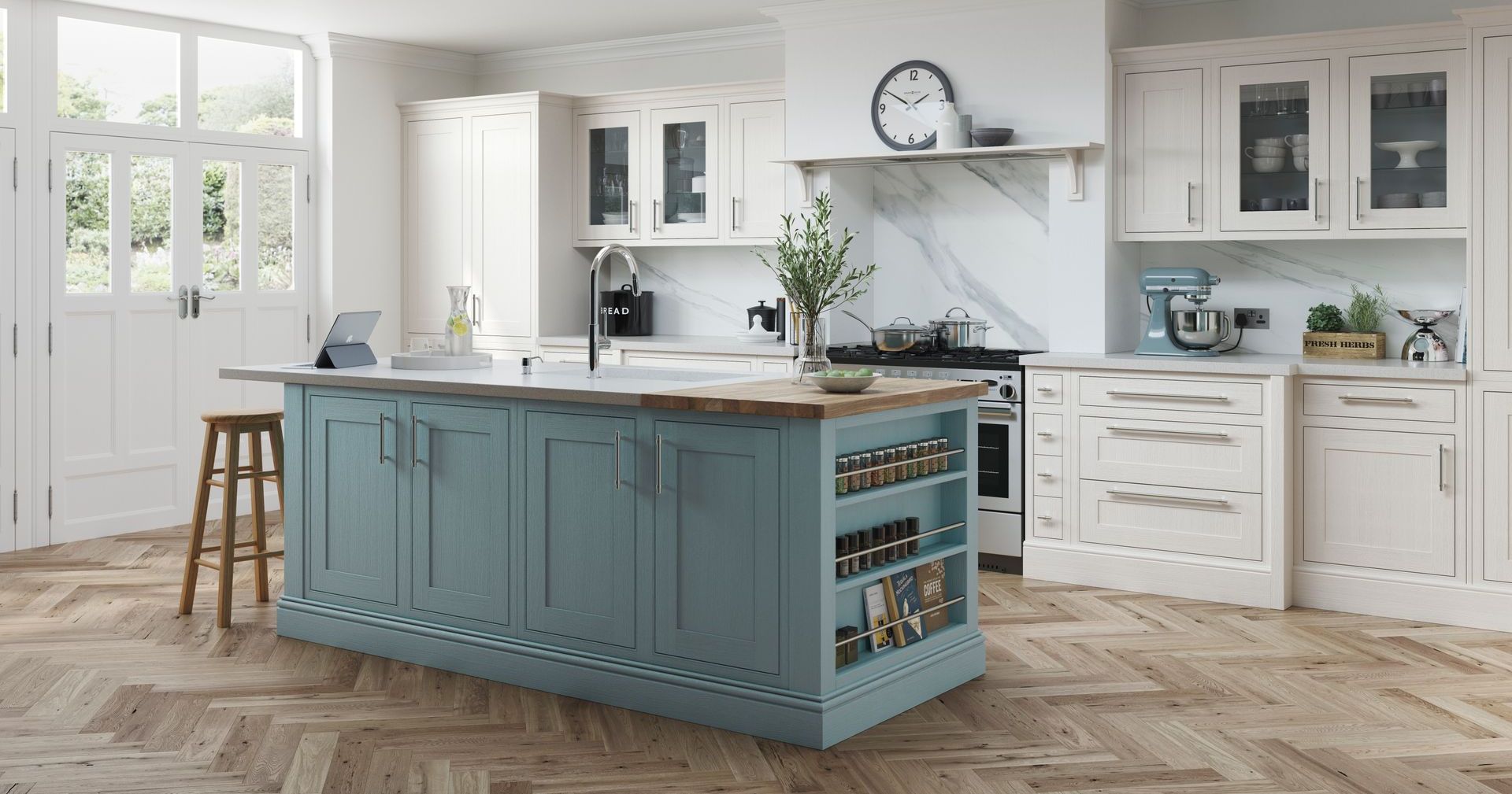 A kitchen with a blue island, off-white cabinetry, wood herringbone floors, and an open door leading to a garden.