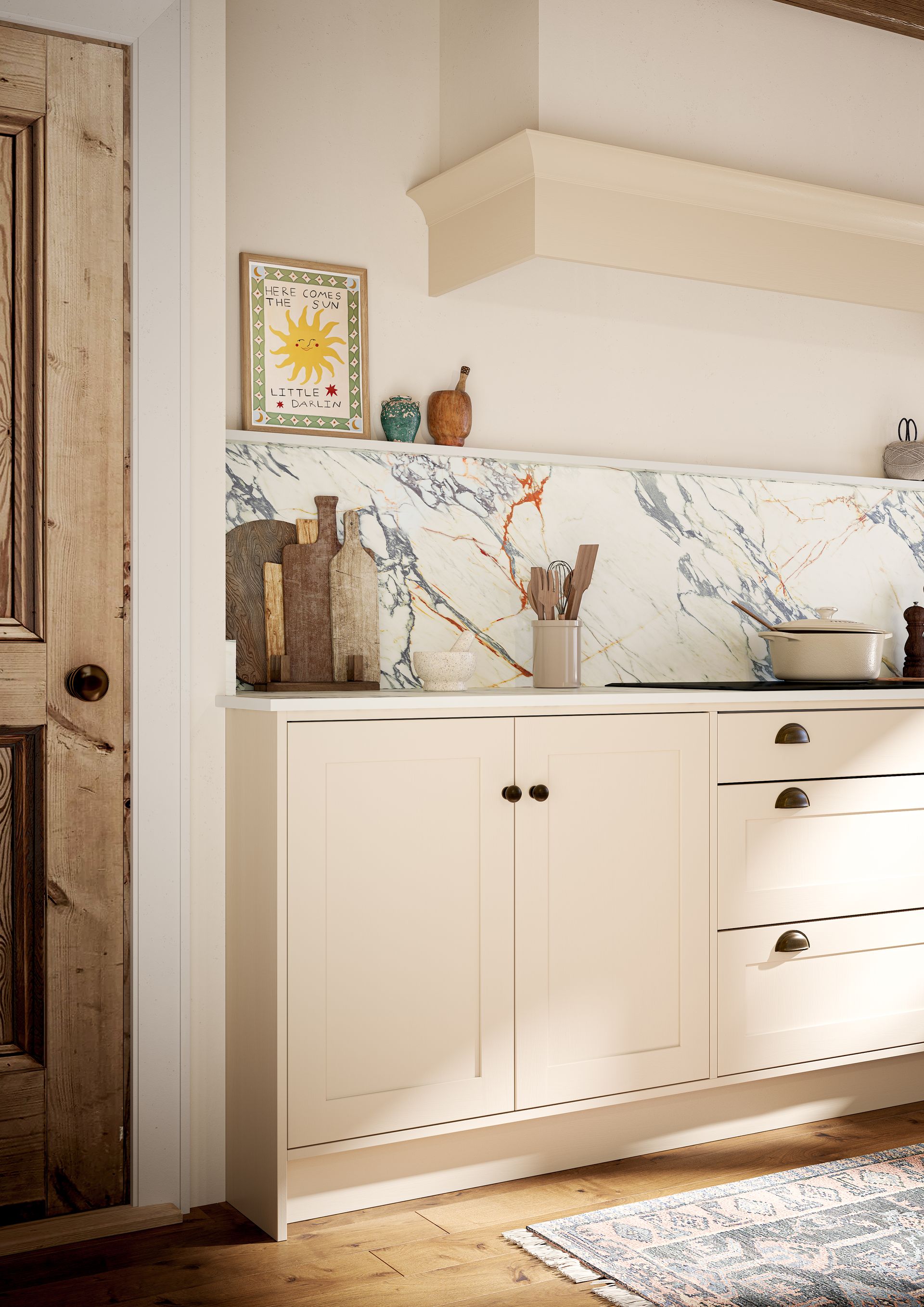 A light-colored kitchen cabinet with marble backsplash, rustic wooden door, and framed sun art on a narrow shelf.