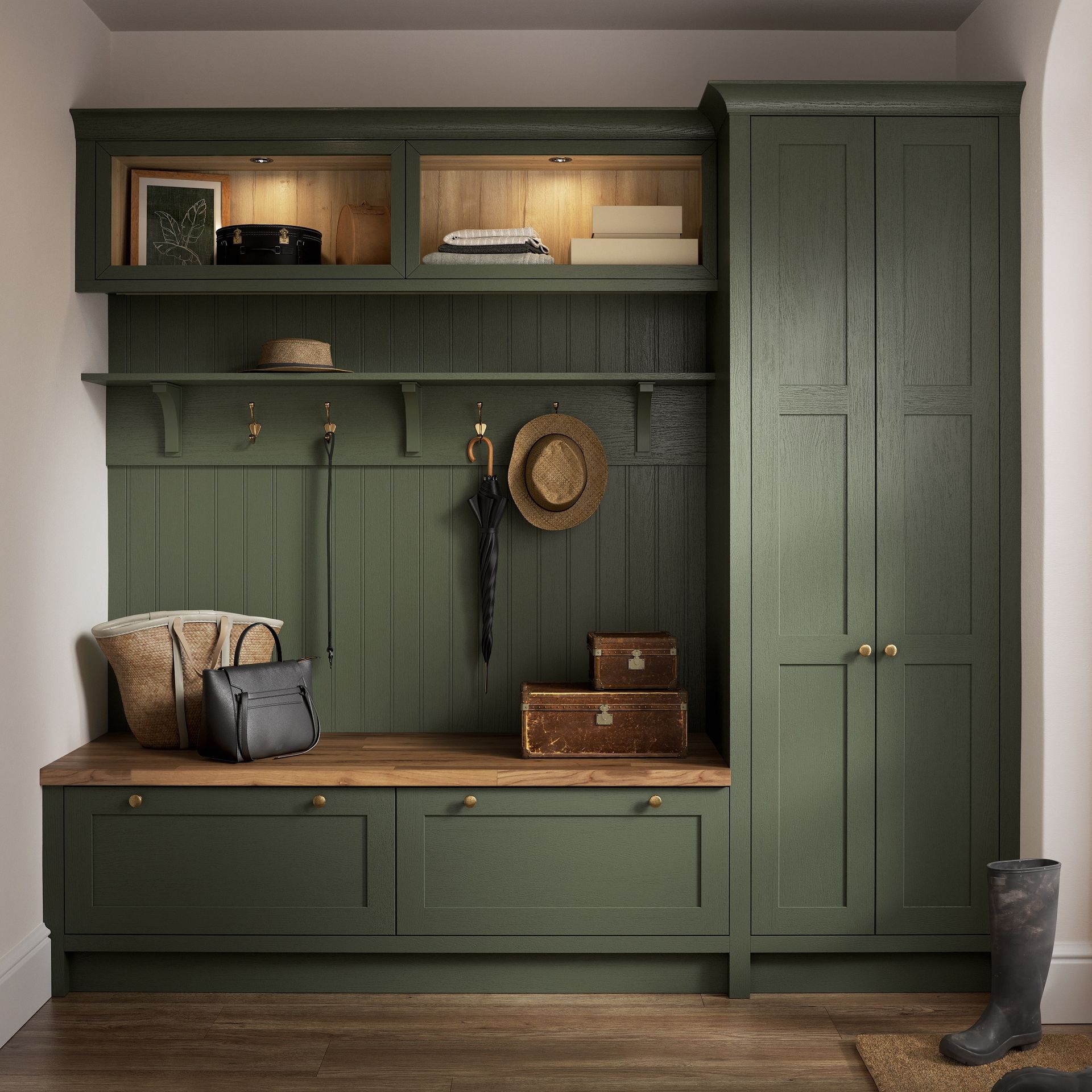 A deep green mudroom built-in with a wooden bench, coat hooks, overhead storage, and a tall cupboard on a wood floor.
