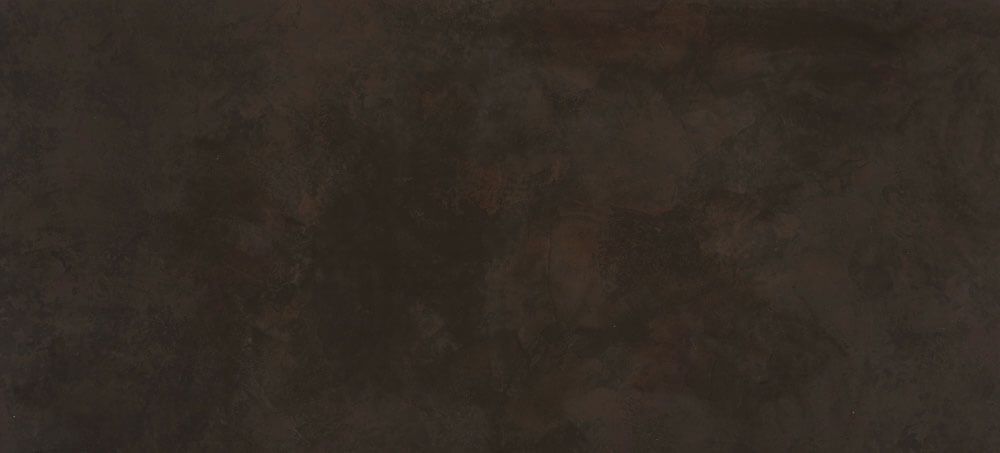 A solid, dark chocolate brown background with a subtle, textured stone or matte finish.