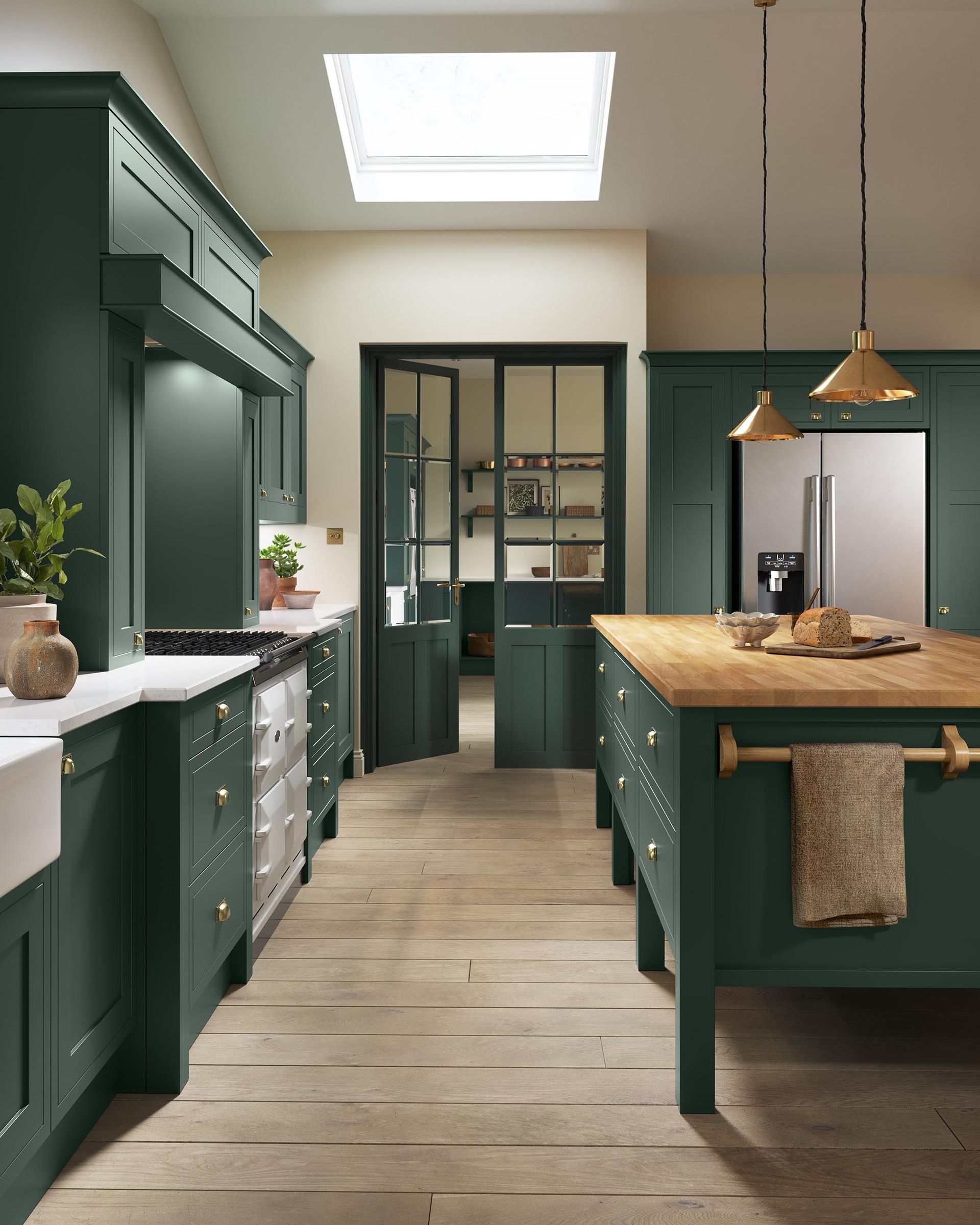 Modern kitchen with dark green cabinets, a wooden island, light wood flooring, and a skylight above a doorway.