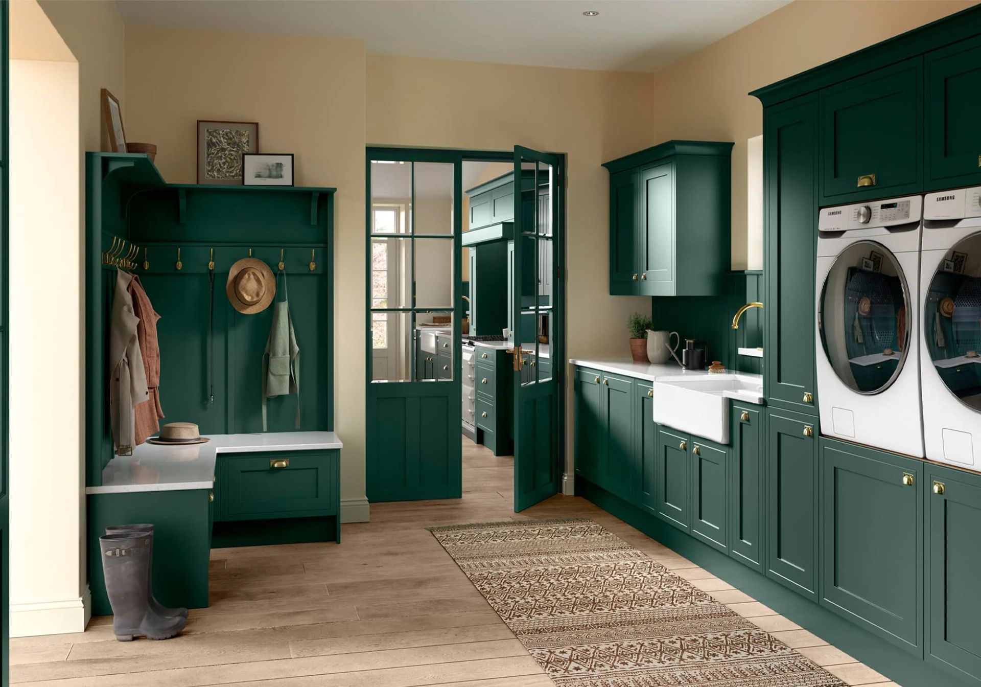 A laundry room with dark green shaker-style cabinetry, a farmhouse sink, integrated appliances, and a built-in mudroom bench.