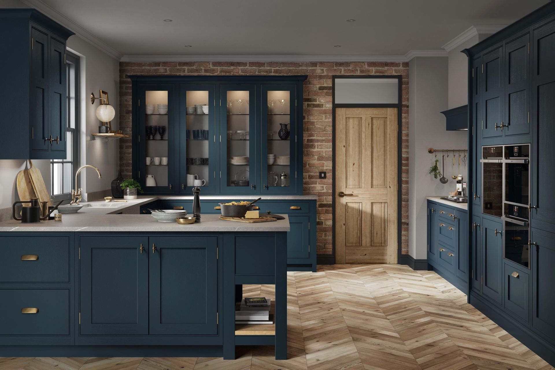 A modern kitchen with dark blue cabinetry, light countertops, exposed brick wall, and light wood herringbone flooring.