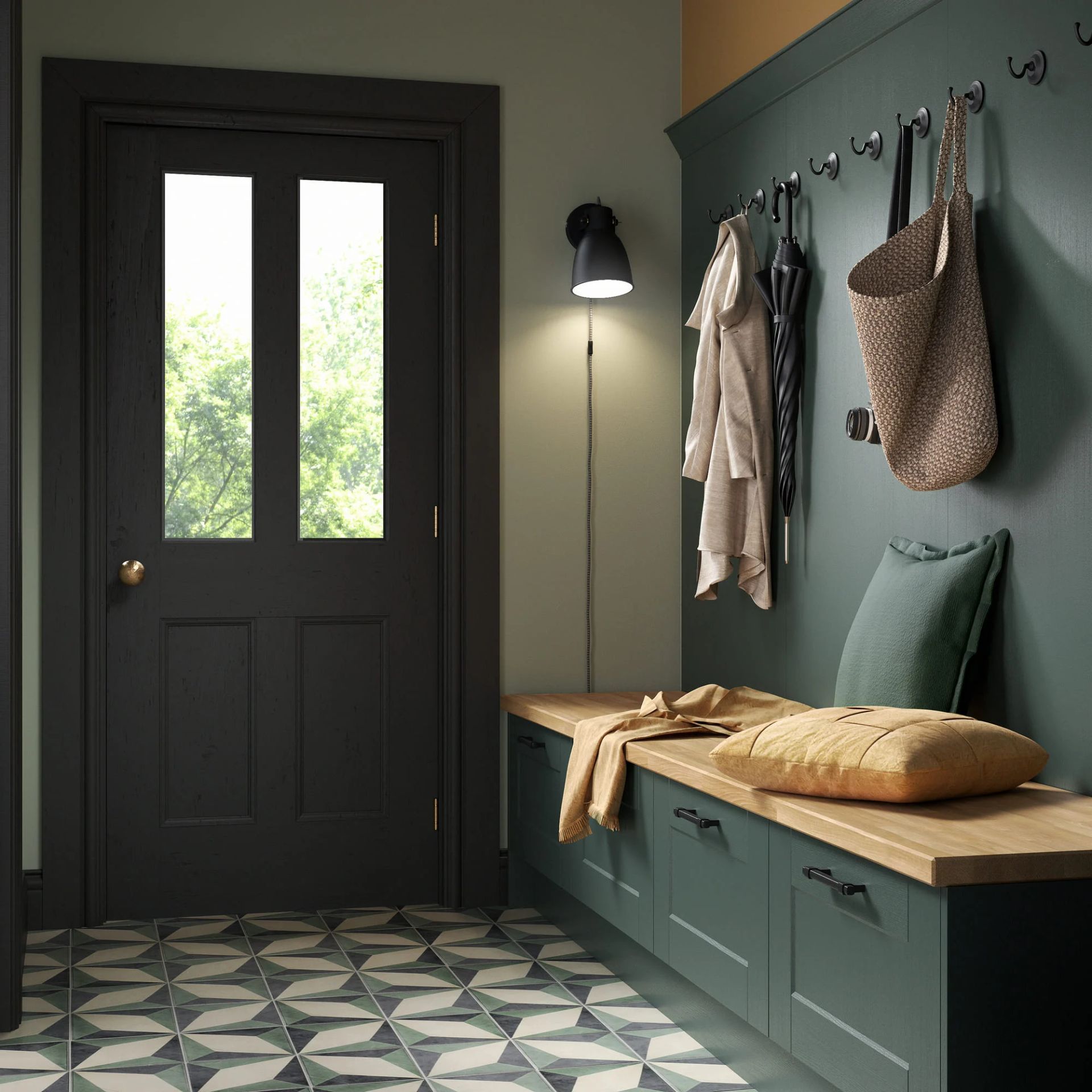 An entryway featuring a dark door, patterned tile floor, a deep green storage bench with cushions, and wall-mounted hooks.