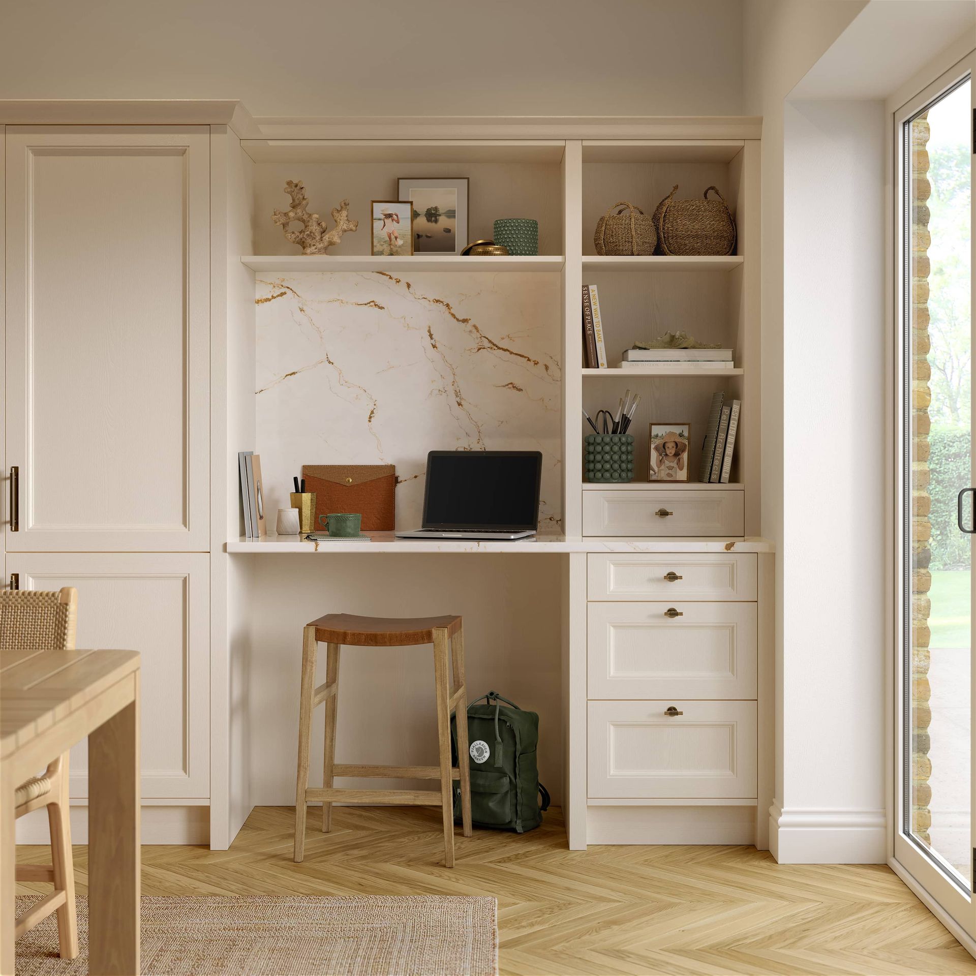 Built-in desk nook with white cabinets, marble backsplash, stool, and shelves beside a sunlit glass door
