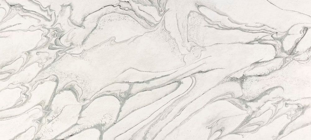 A white stone surface featuring prominent, flowing gray veins in a marbled pattern.