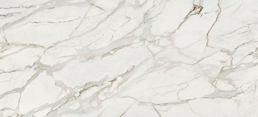 A close-up of white marble with intricate, soft grey and golden-brown veining patterns.