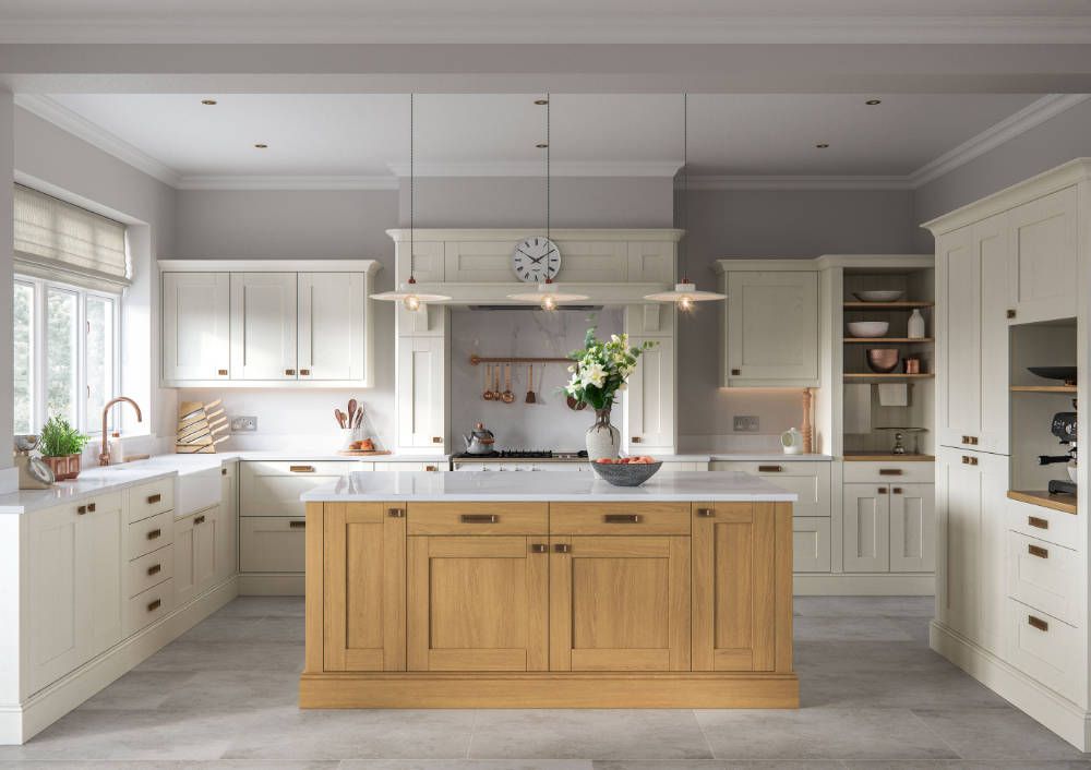 A bright, spacious kitchen featuring white cabinetry, a light wood center island, and three hanging pendant lights.
