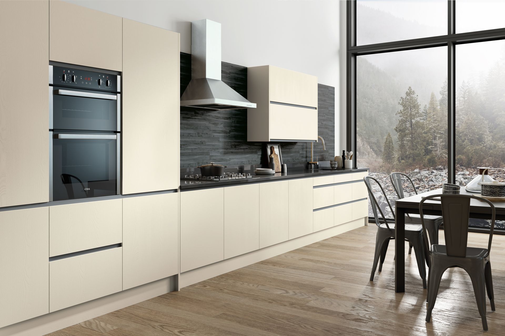 Modern kitchen with matte cream cabinets, black stone backsplash, built-in oven, and dining area overlooking a forest.