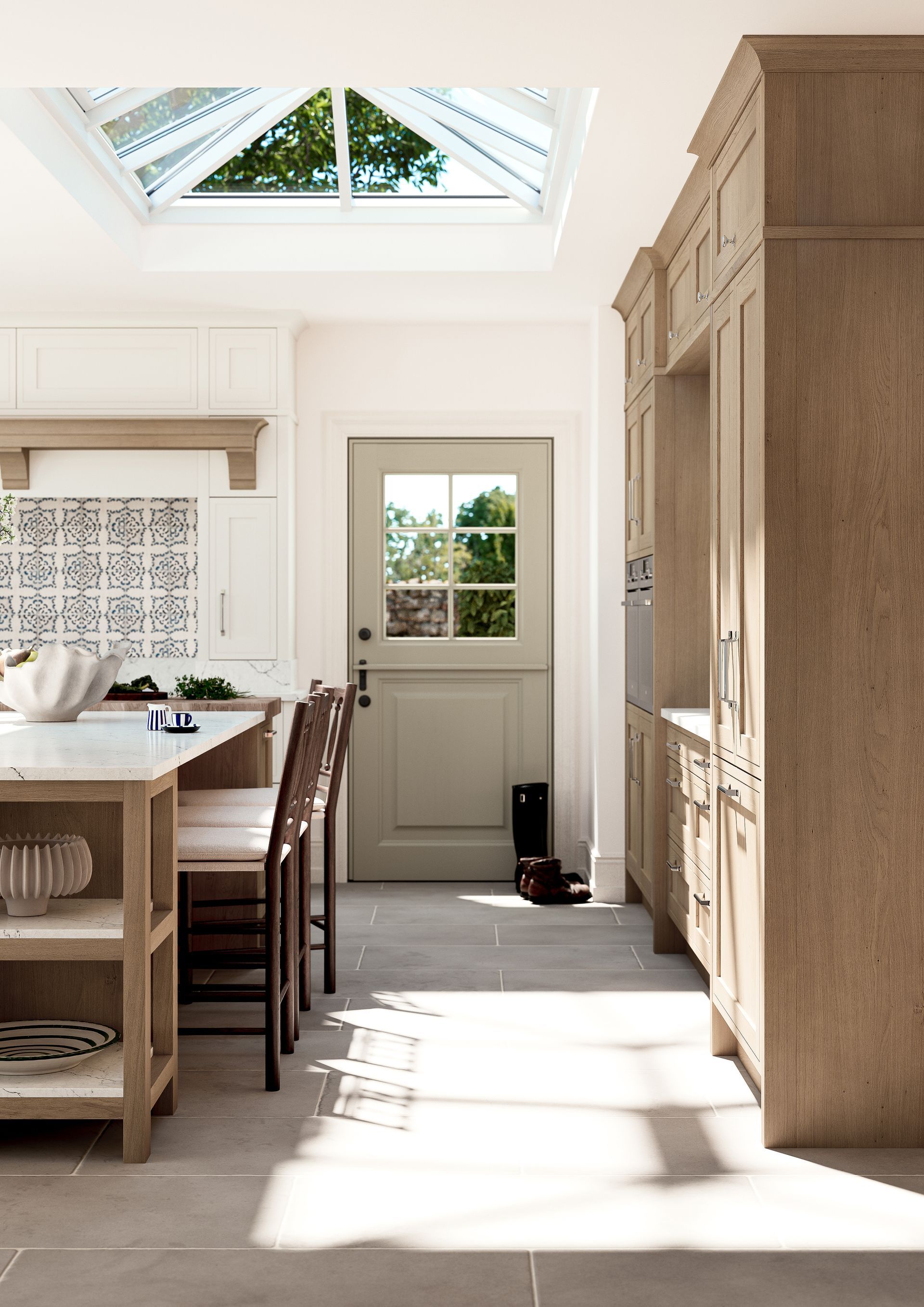 A light-filled kitchen with wooden cabinetry, a central island, patterned backsplash, and a stable door under a skylight.