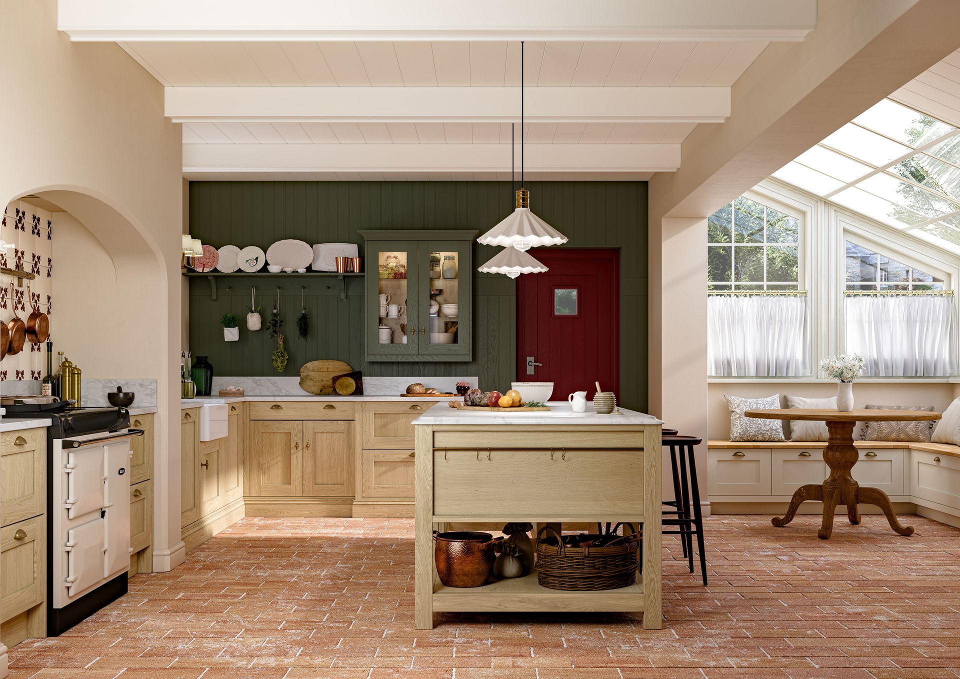 A rustic kitchen with wood cabinets, green walls, a central island, and a dining nook by windows with terracotta floors.