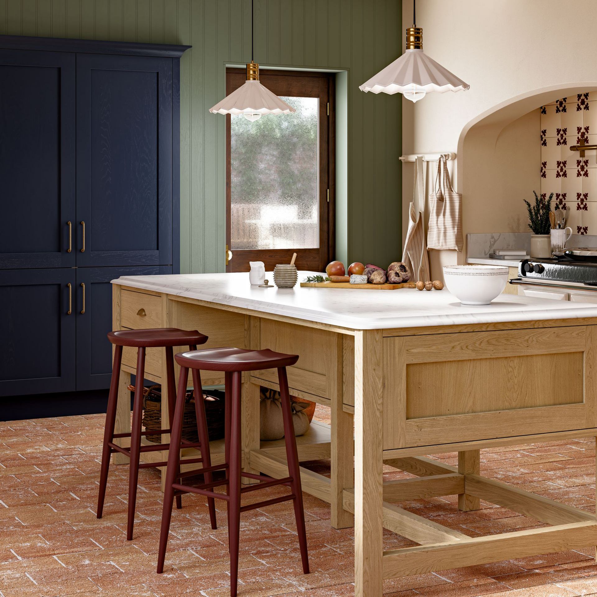 A kitchen island with a light wood base and white top sits on a brick floor, flanked by two stools in front of green walls.