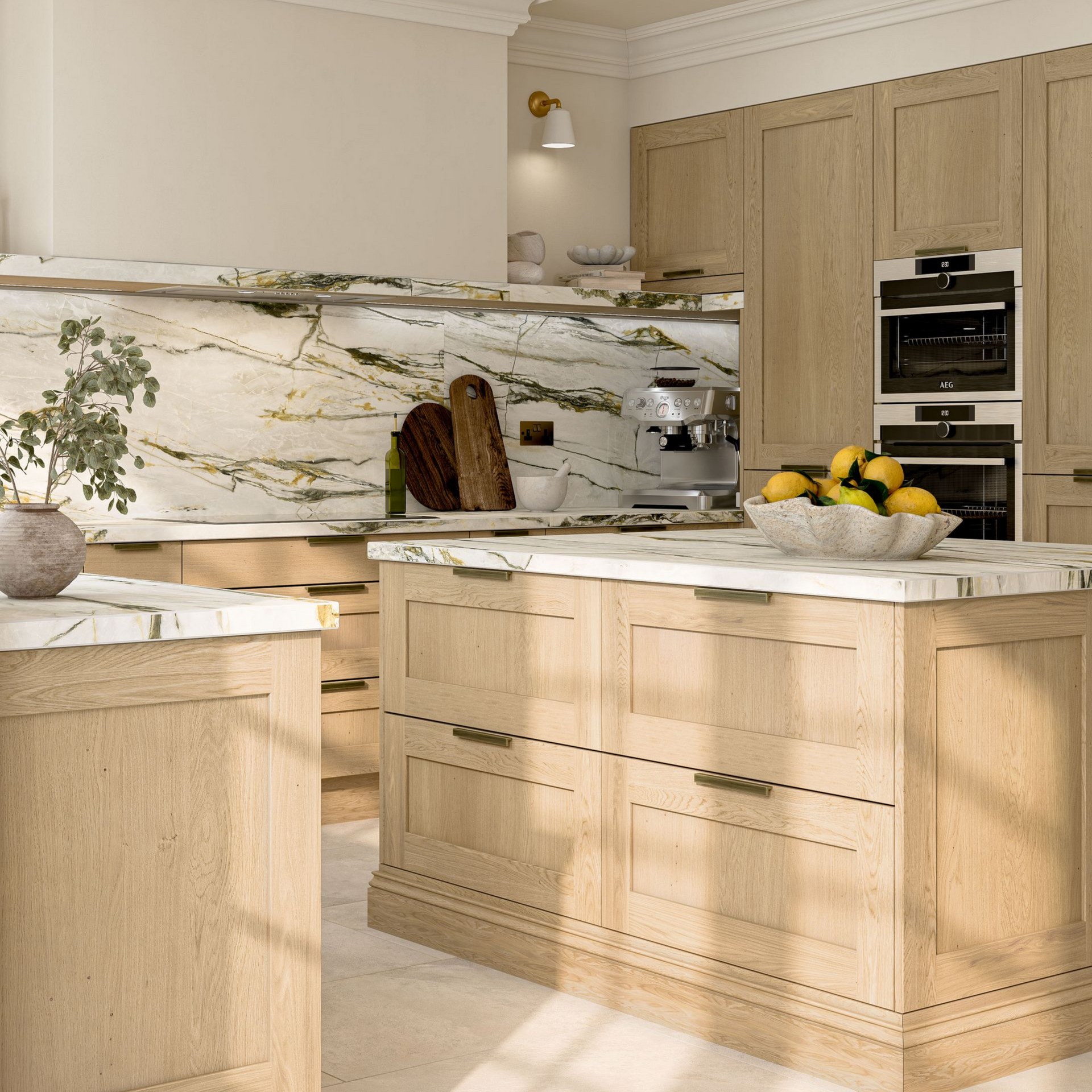 A modern kitchen featuring light oak cabinets, a white marble island with gold handles, and a veined marble backsplash.