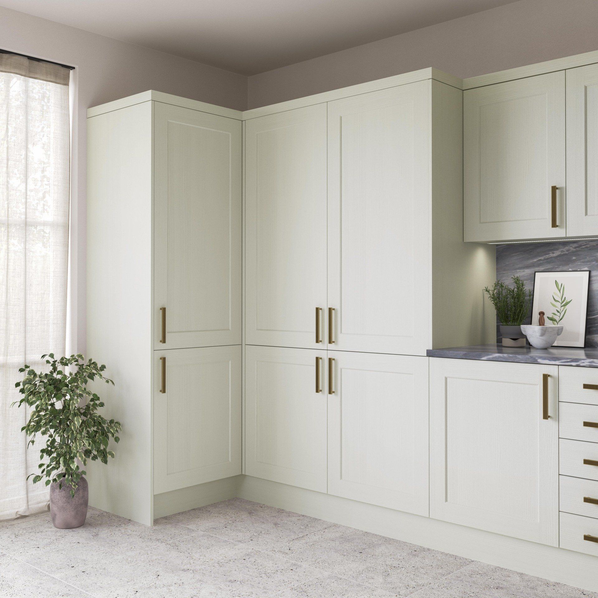 A corner kitchen featuring cream-colored Shaker-style cabinets with gold hardware and a grey marble backsplash.