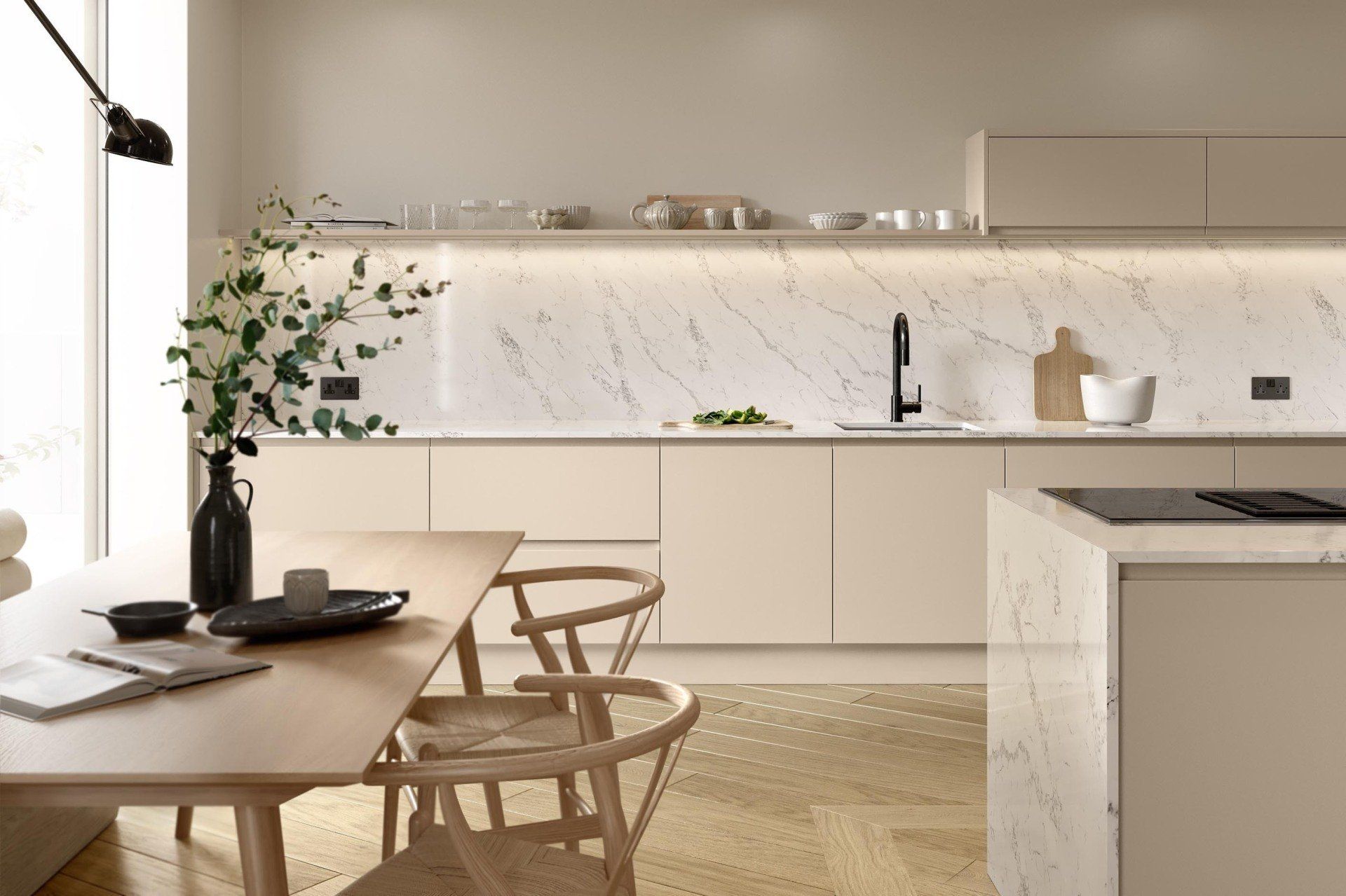 Modern minimalist kitchen featuring matte beige cabinets, white marble backsplash, wooden table, and herringbone floor.