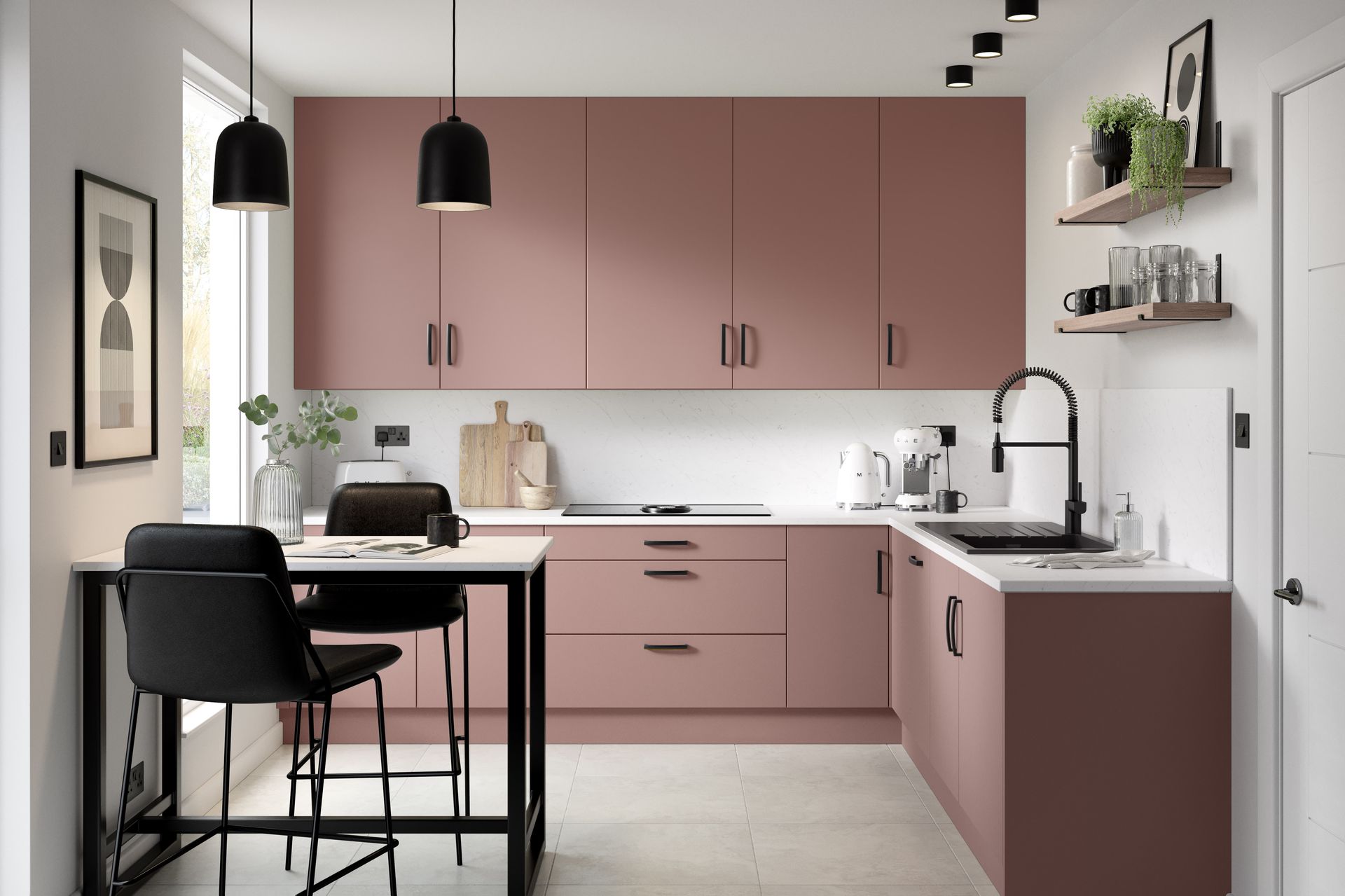A modern kitchen featuring matte dusty-pink cabinets, a white countertop, black fixtures, and a small dining area.