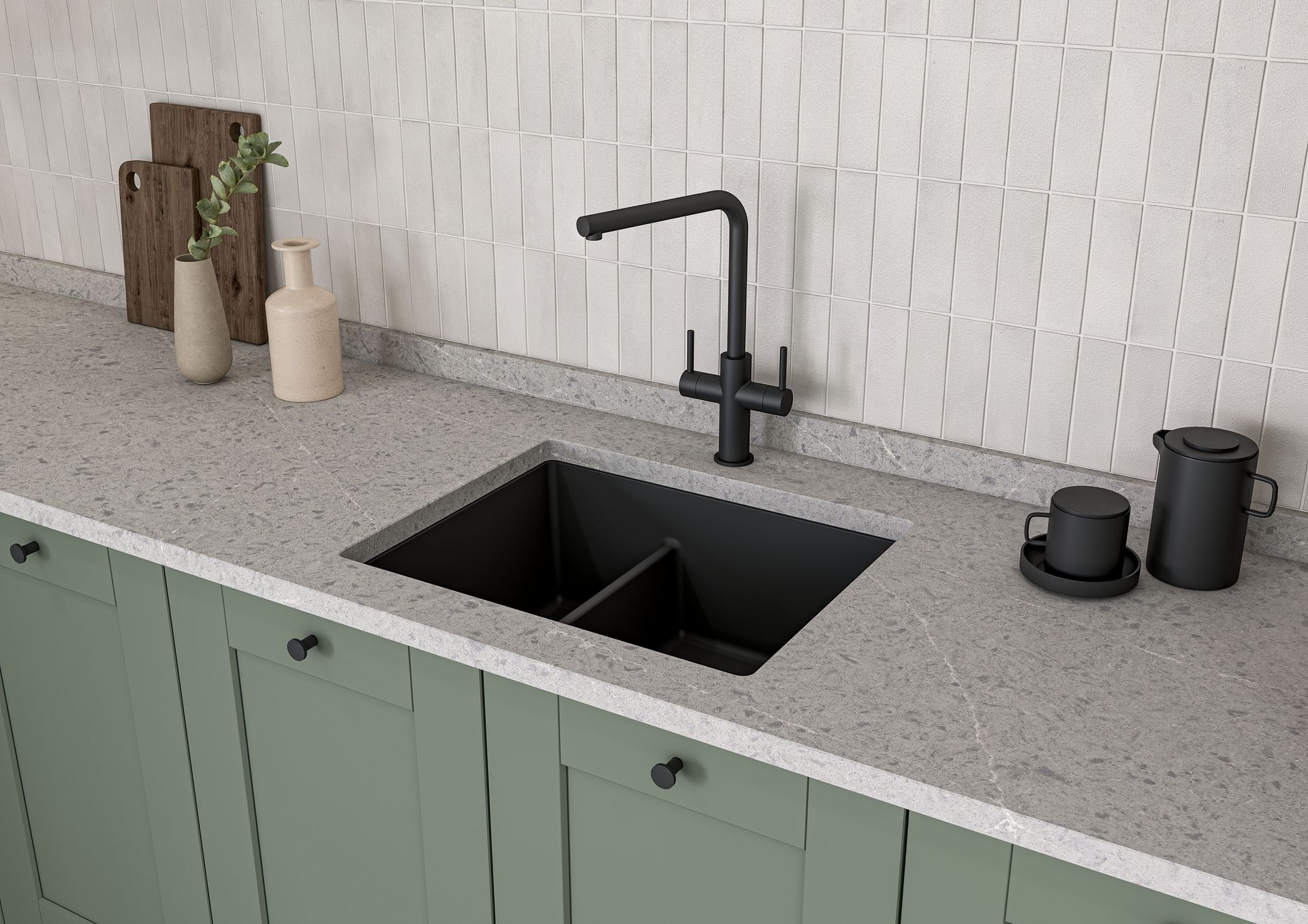 A modern kitchen sink with a black faucet, set into a speckled countertop above sage green cabinets.