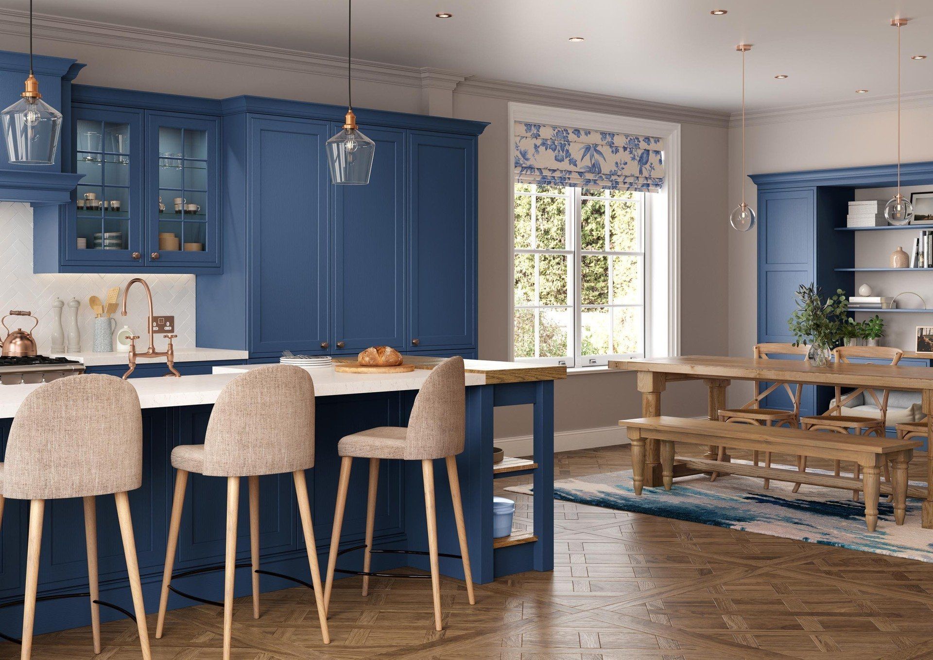A modern kitchen featuring navy blue cabinets, a white marble island with three beige stools, and a wooden dining table.
