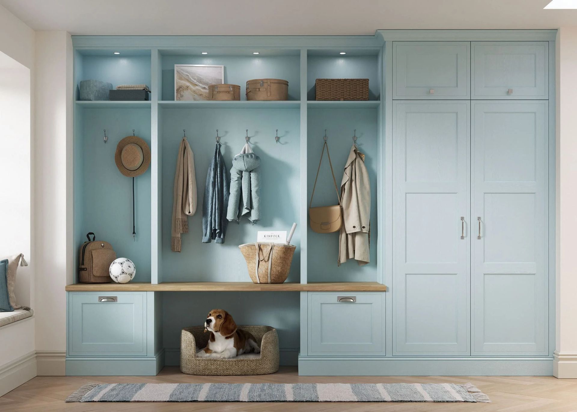Light blue entryway mudroom storage unit with open shelves, coat hooks, a bench, a dog bed with a dog, and a tall cabinet.