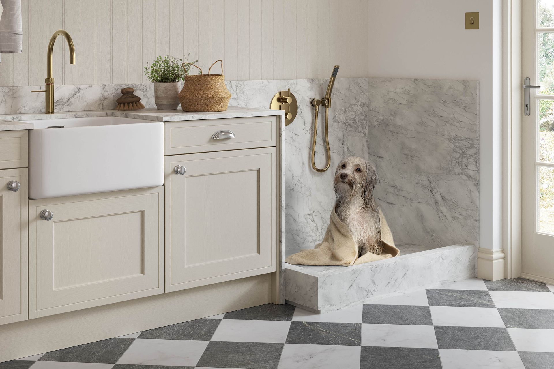 A wet dog in a towel sits on a marble-tiled pet shower platform next to a farmhouse sink in a kitchen.
