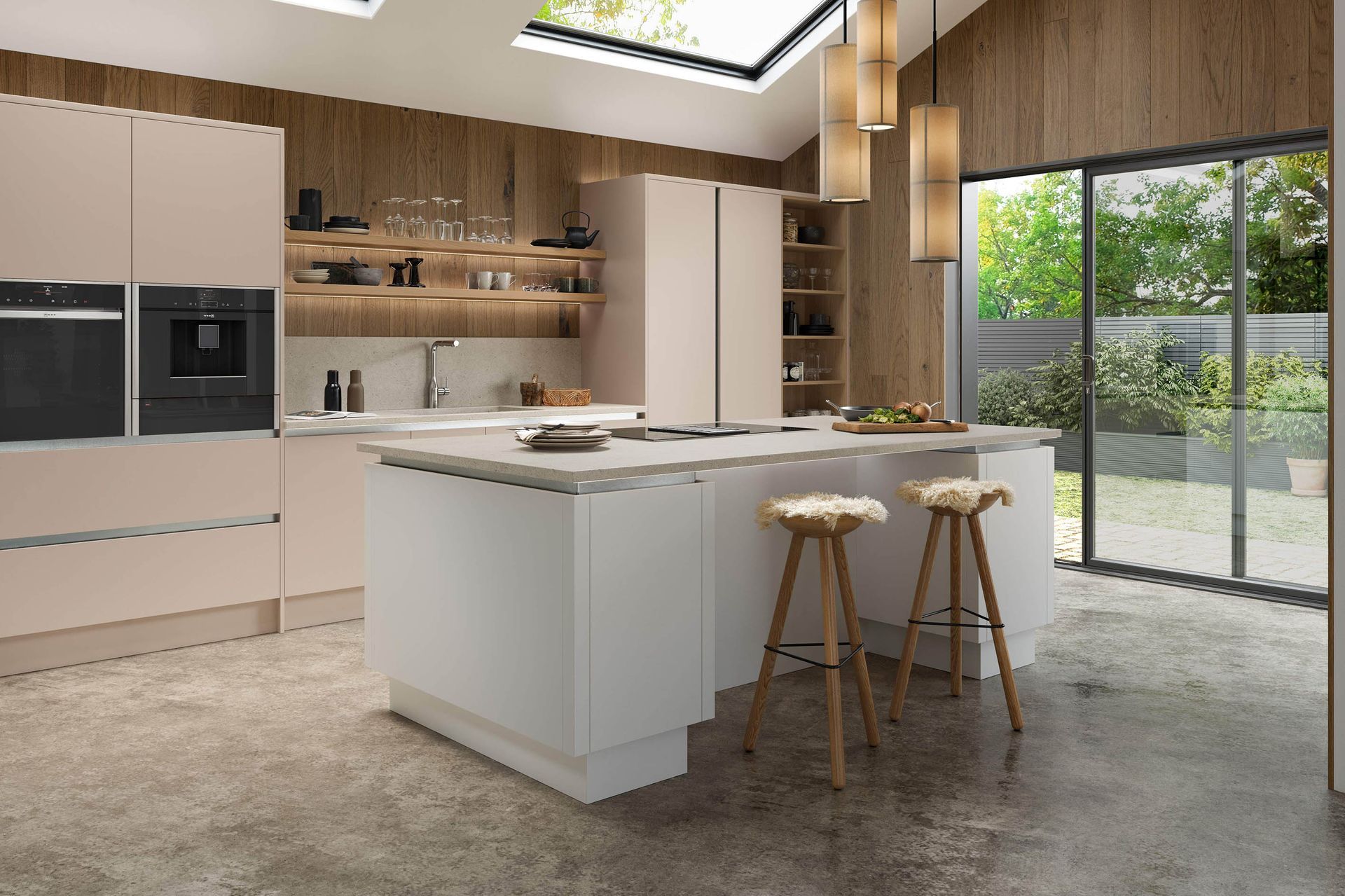 A modern kitchen with blush cabinets, a white island with two stools, wood-paneled walls, and large sliding glass doors.