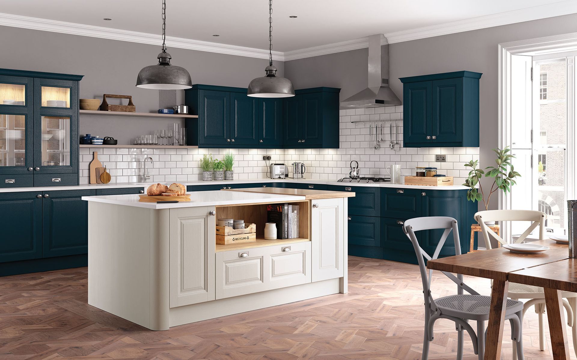 A kitchen with dark blue cabinetry, white subway tiles, a light-colored kitchen island, and a wooden dining set.
