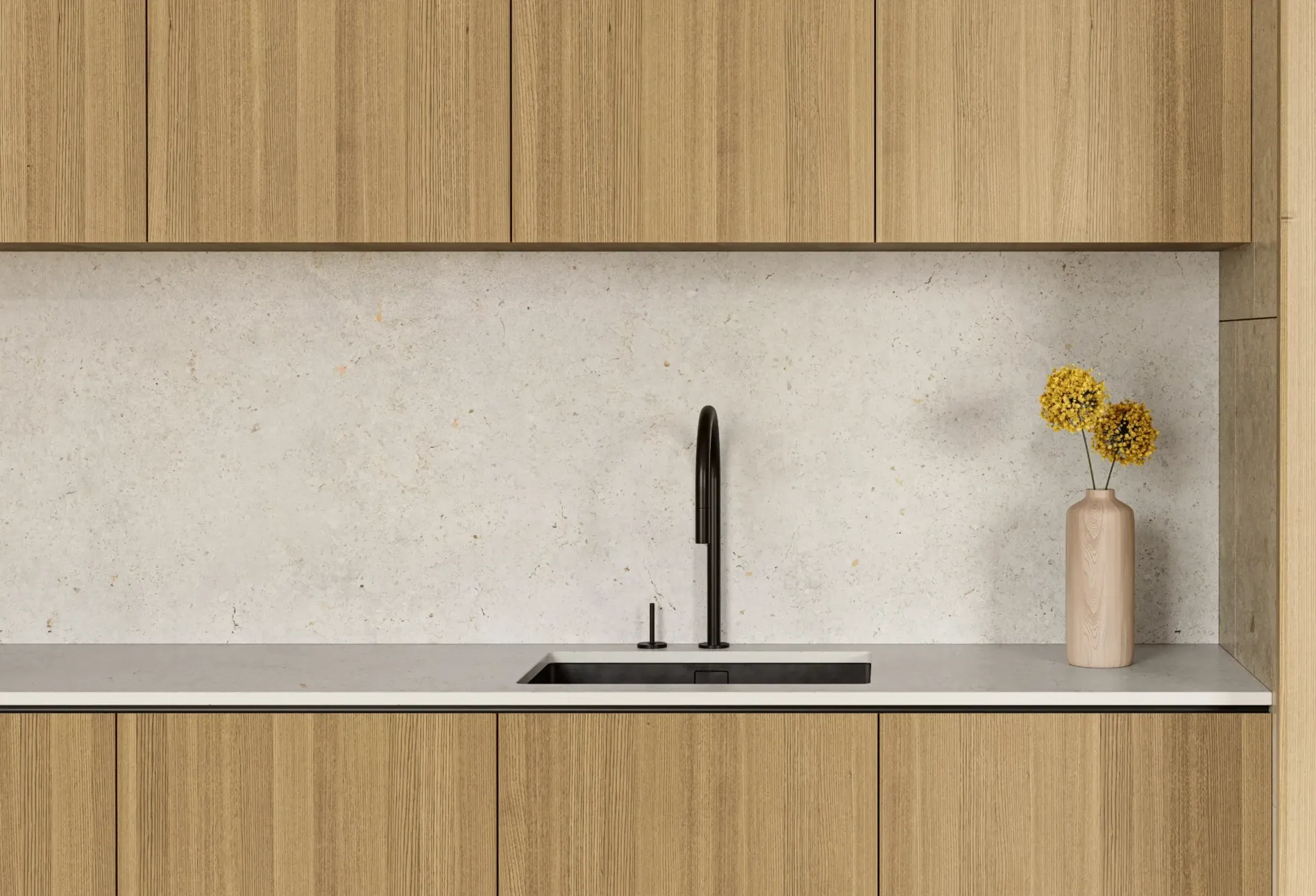 A modern kitchen sink with a matte black faucet, light wood cabinetry, and a textured, speckled off-white backsplash.