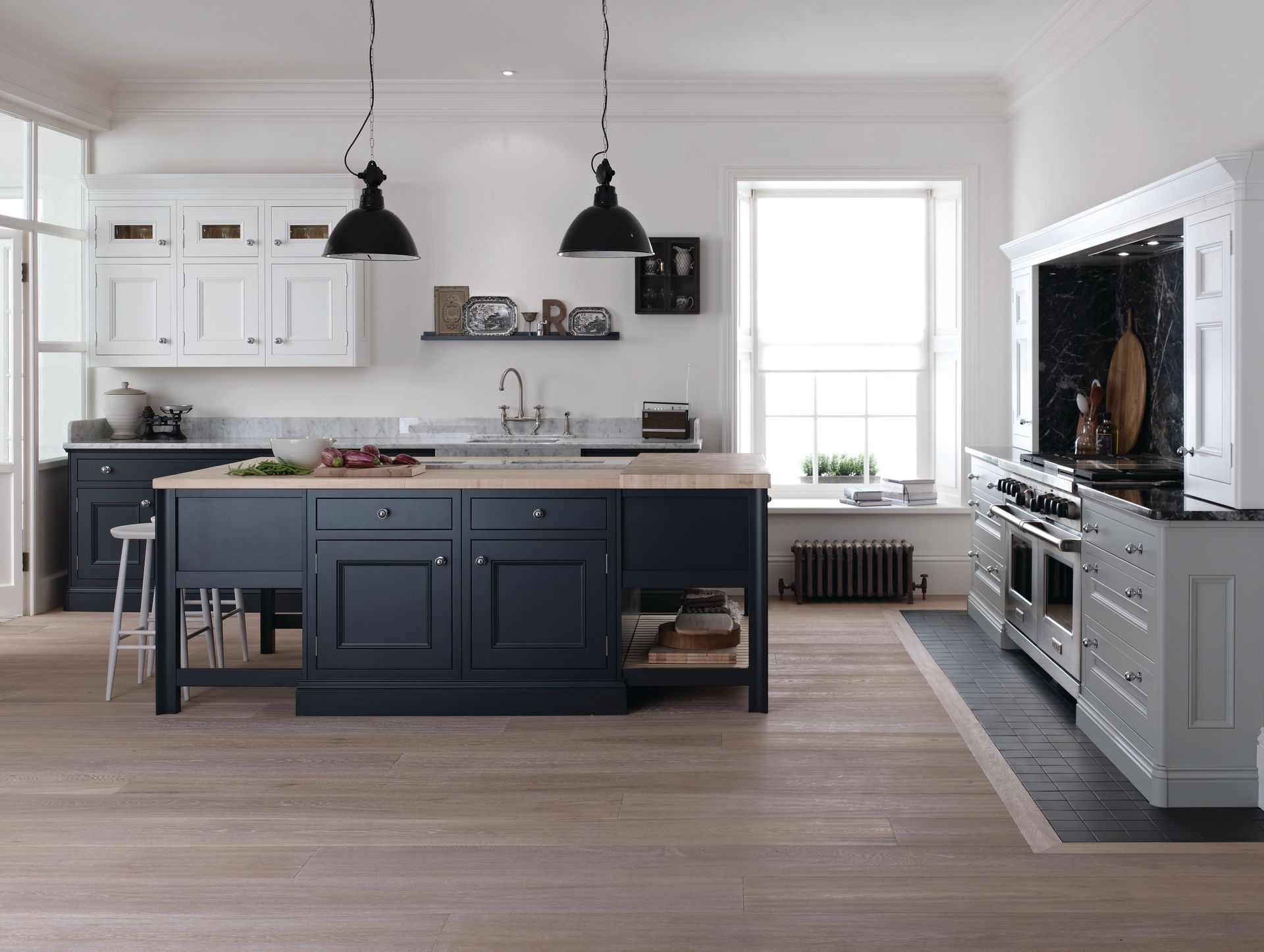 A modern kitchen featuring a dark blue island with a wooden countertop, white upper cabinets, and a stainless steel stove.