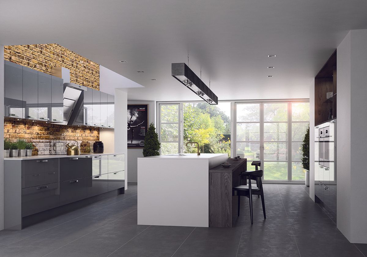 A modern kitchen featuring grey cabinets, a central white island with seating, and a stone-textured wall section.