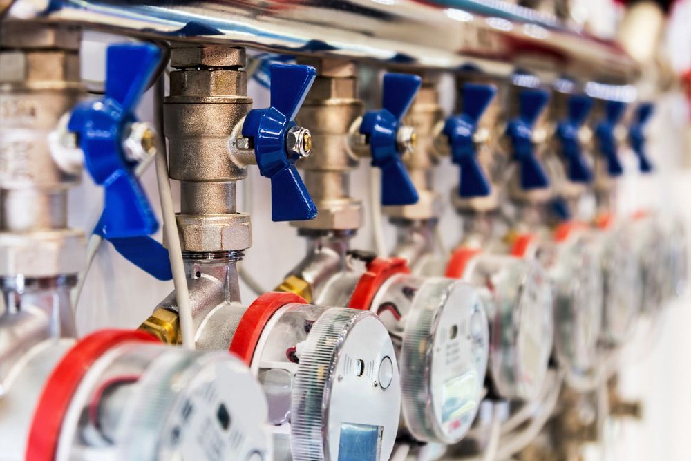 A Row Of Valves With Blue Handles Are Lined Up In A Row — Tim Larkin Plumbing and Excavations in Laurieton, NSW