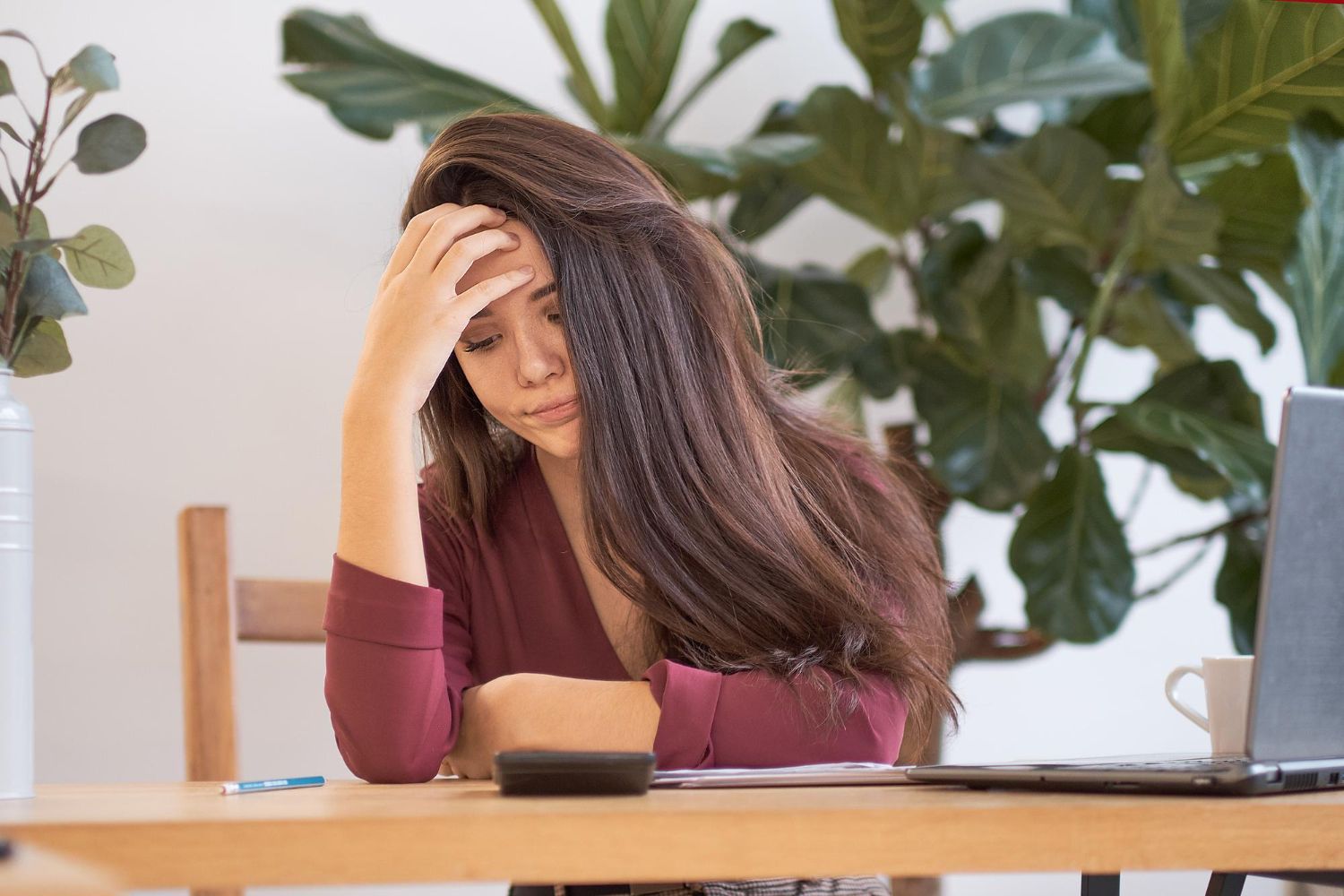 Woman with her head in her hadns looking distressed