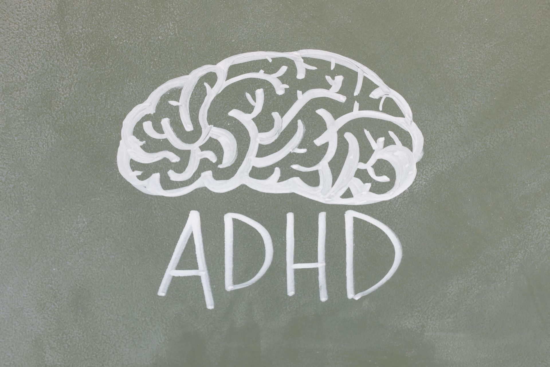 A chalkboard with a brain and the word adhd written on it