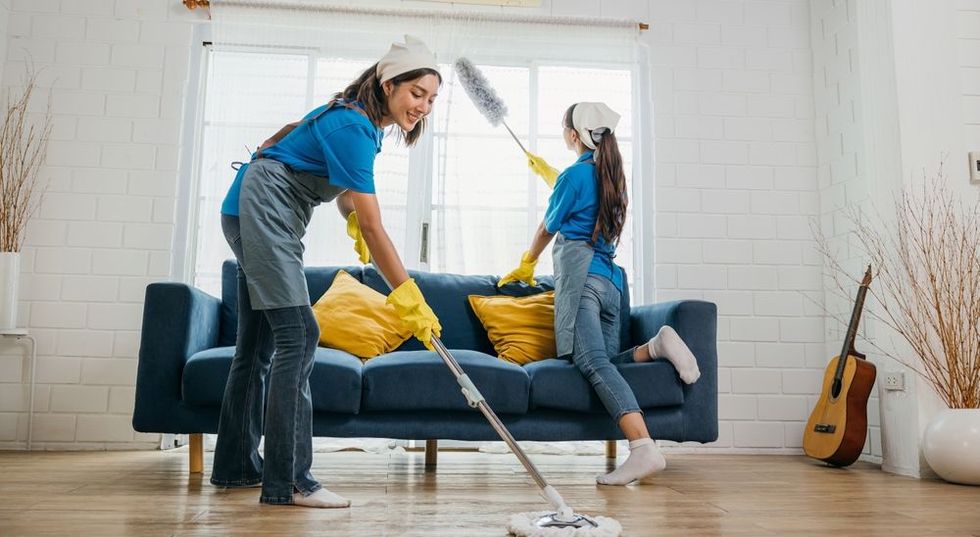 A woman and a child are cleaning a living room.
