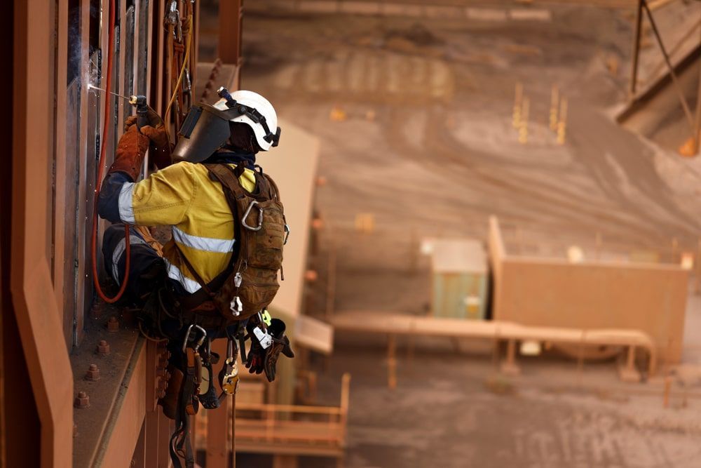 Man Working At The Side Of A Building — Calibre Engineering In Mount Isa, QLD