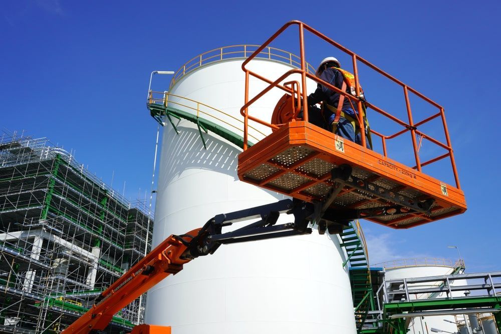Man Standing On A Platform In Front Of A Large White Tank — Calibre Engineering In Mica Creak, QLD