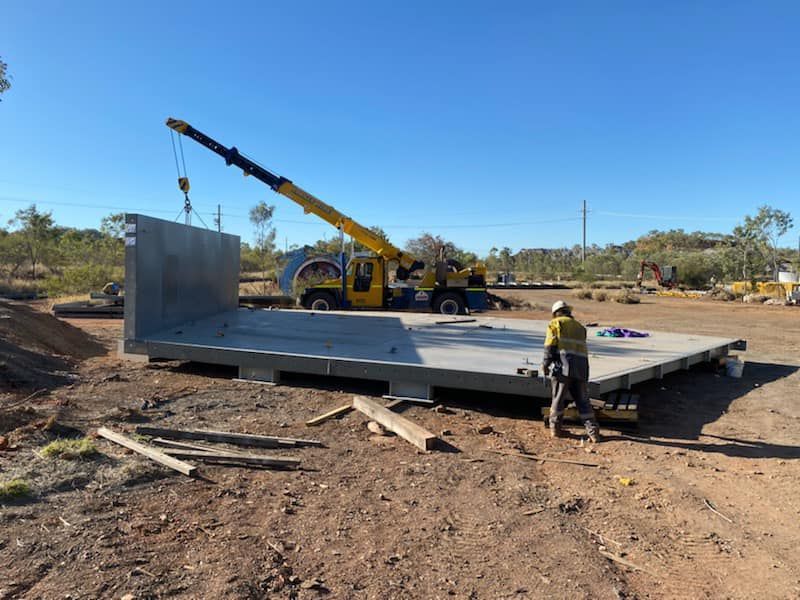 Crane Lifting A Large Piece Of Concrete In A Dirt Field — Calibre Engineering In Mica Creak, QLD