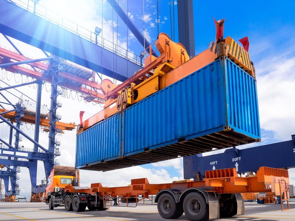 Blue Shipping Container Being Lifted By A Crane On A Trailer — Calibre Engineering In Darwin, NT
