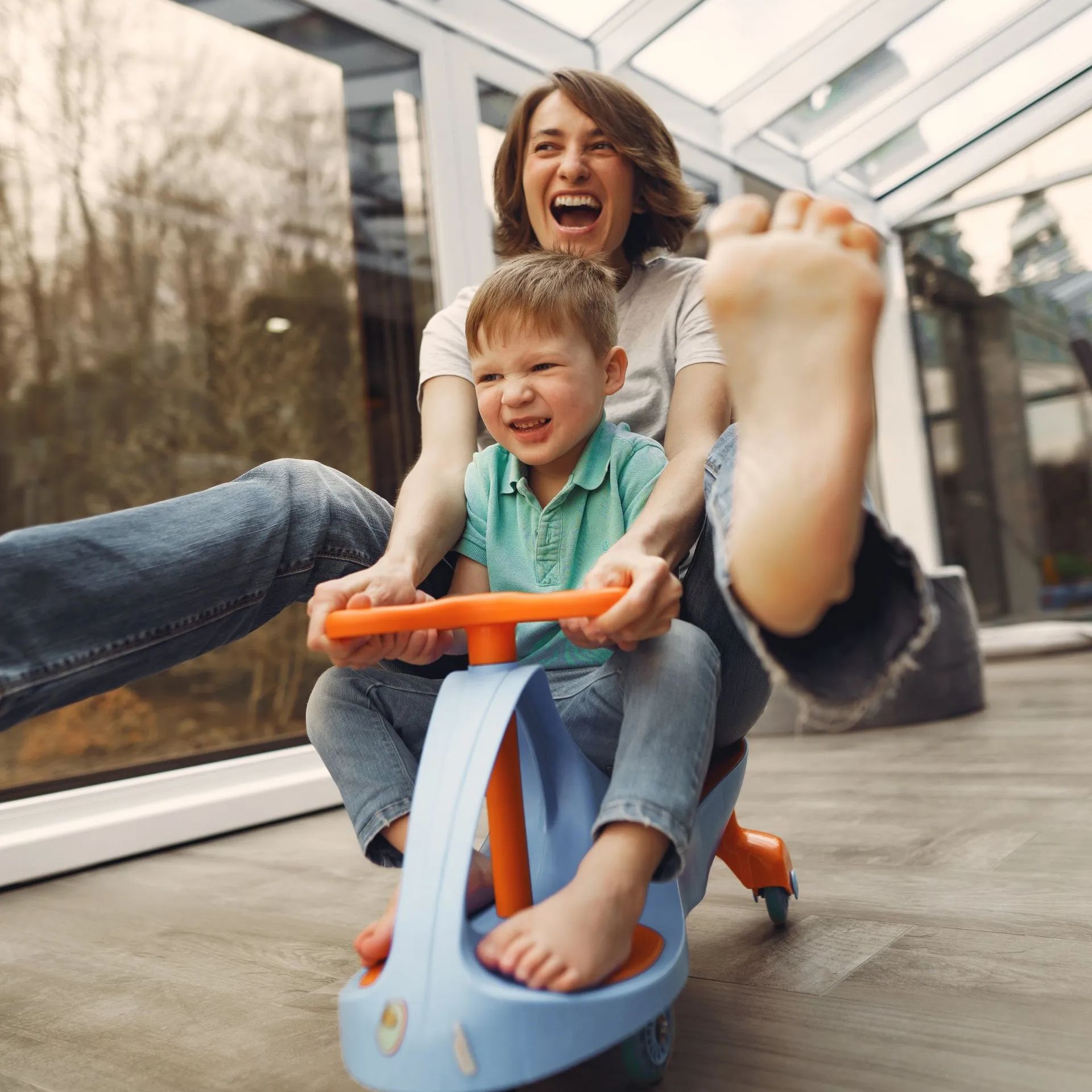 A woman and a child are playing with a toy car.