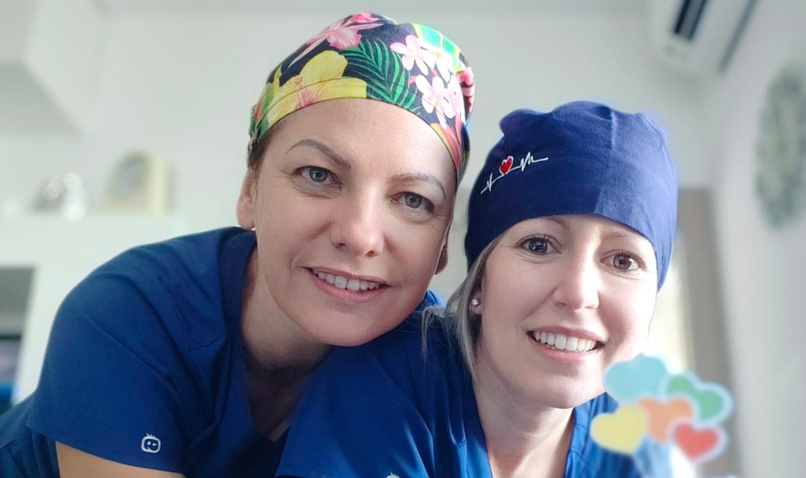 Due donne che indossano camici e cappelli posano per una foto - Arte Dentale Frosinone